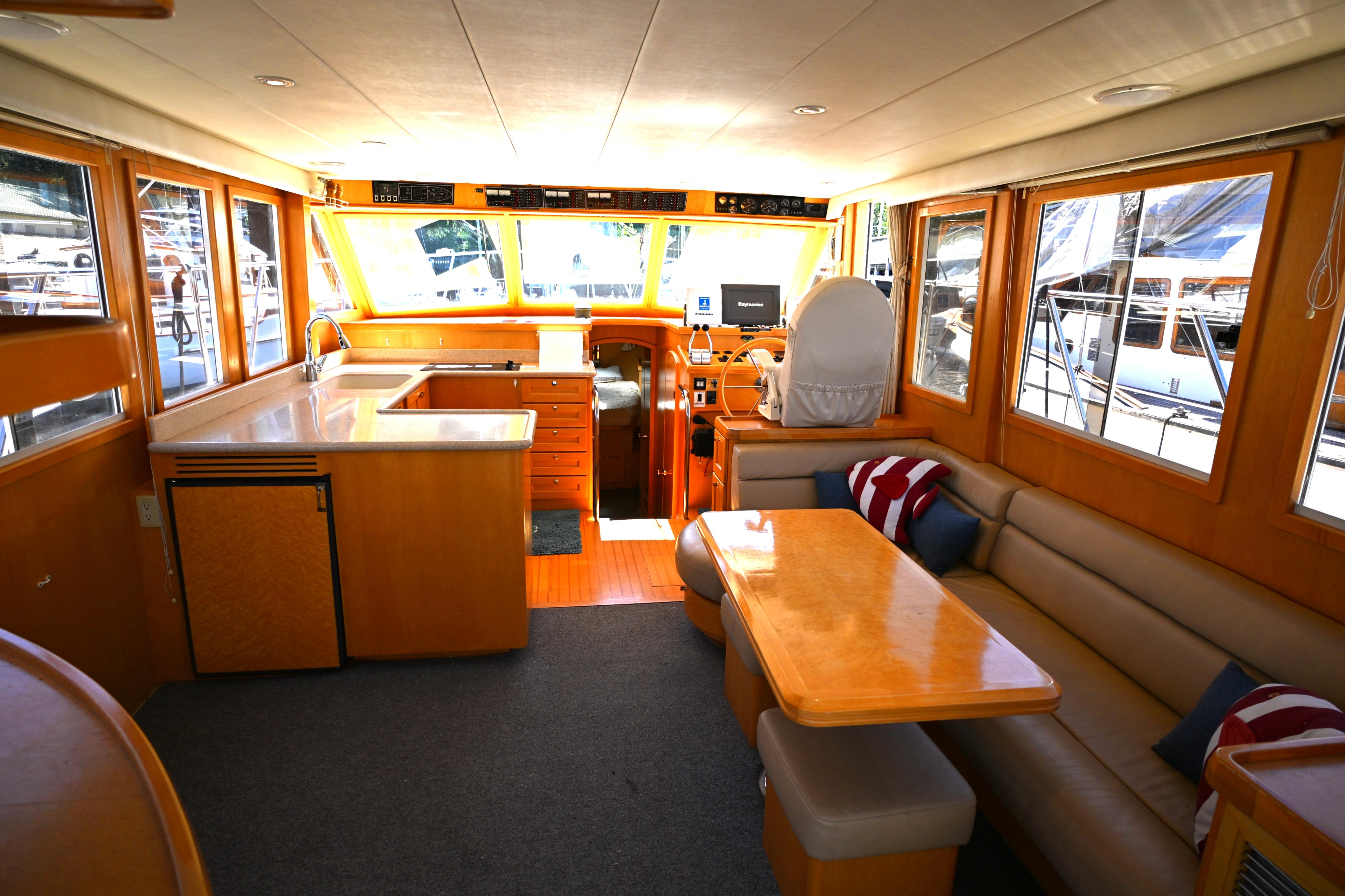 Interior of a 1999 McKinna 47 Sedan yacht with seating and helm.
