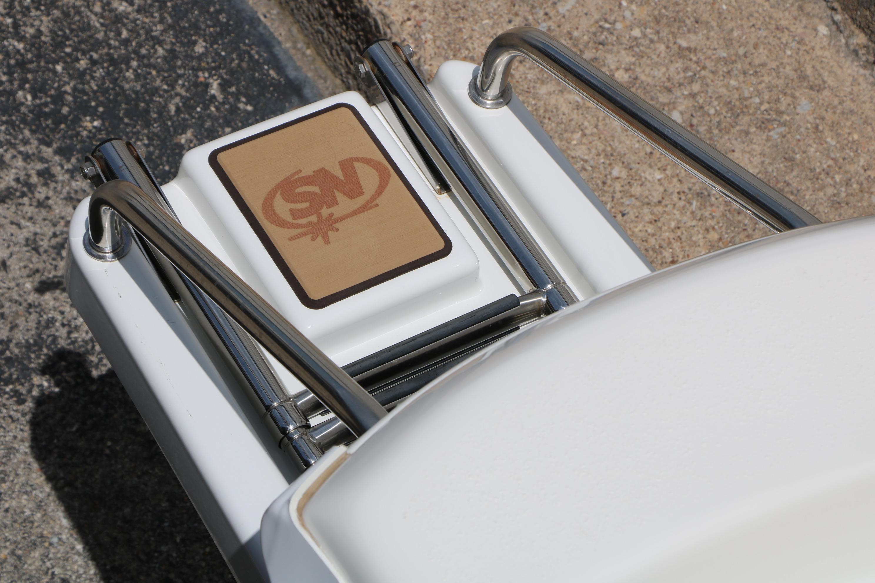 2020 NauticStar 2140 Sport boat ladder with logo, featuring stainless steel rails.
