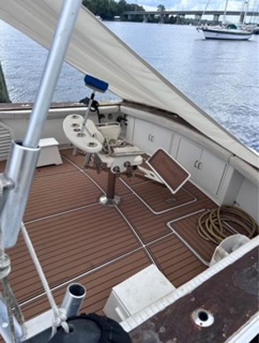 1986 Egg Harbor 60 Sportfisherman boat deck with fishing chair and equipment, docked by the water.