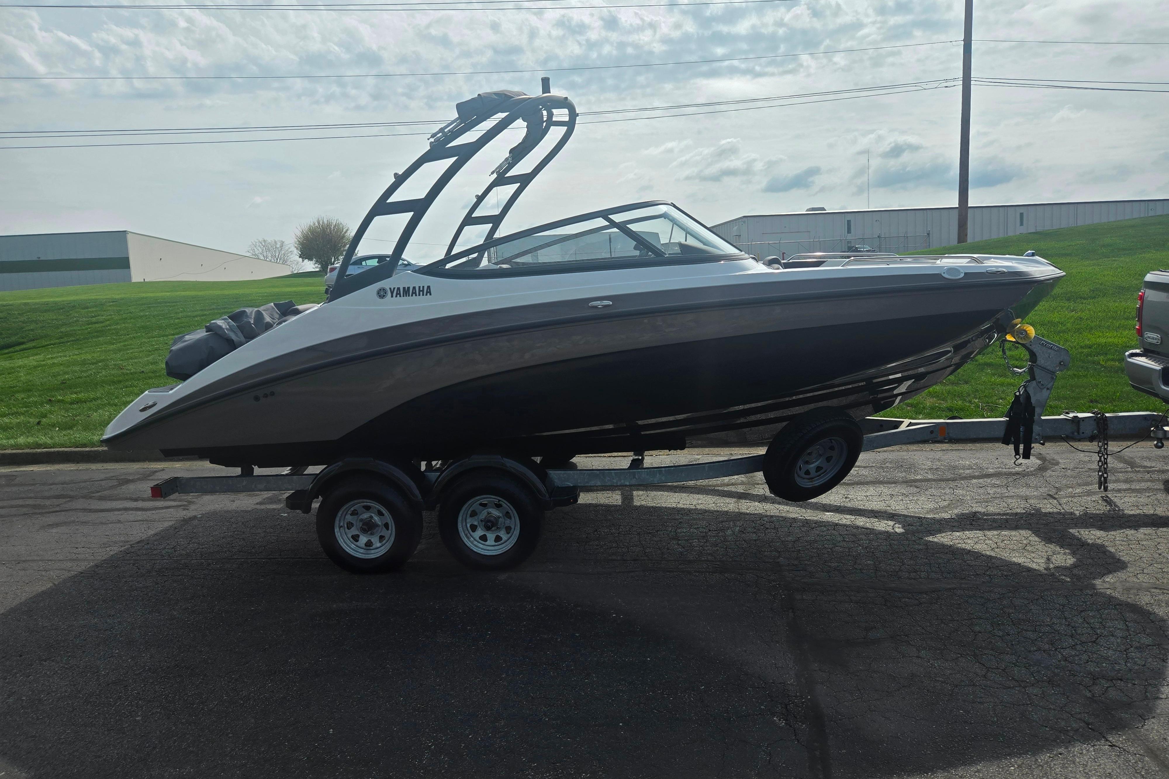 2022 Yamaha Boats AR210 on trailer, parked outdoors under cloudy sky.