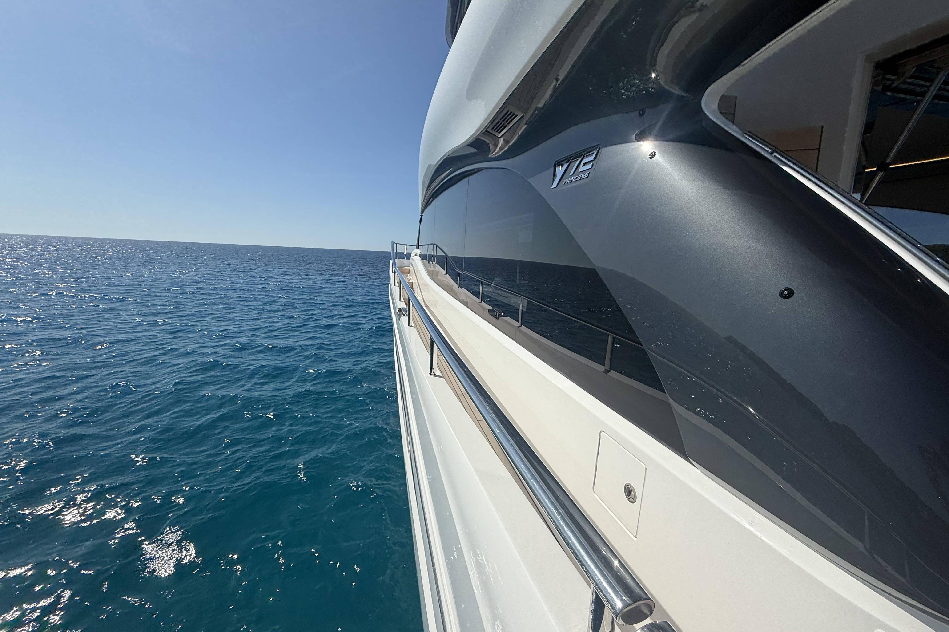 2025 Princess Y72 yacht cruising on open sea under clear blue sky.
