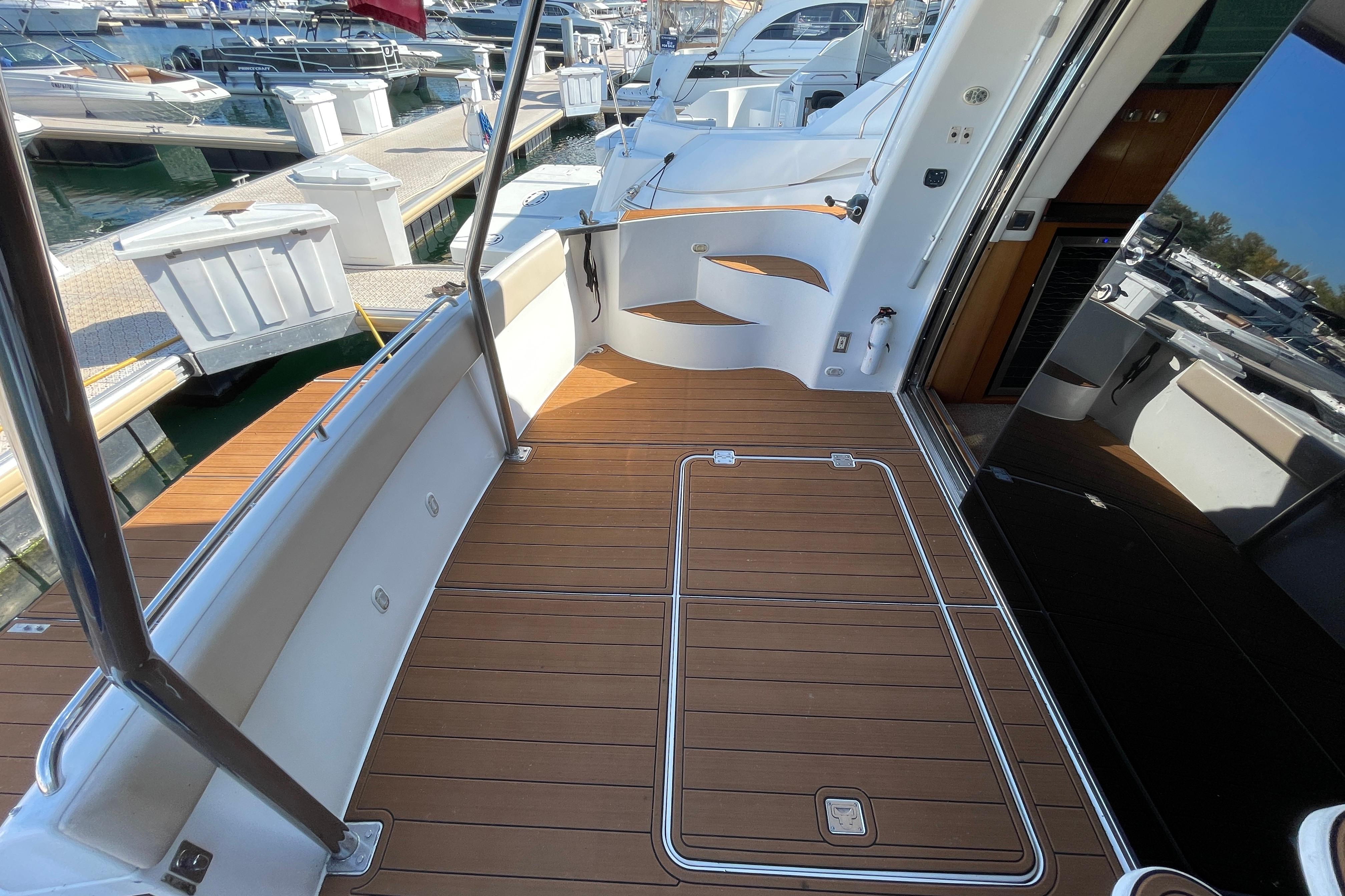 2002 Carver 570 Voyager Pilothouse yacht deck with wood finish, docked at marina.