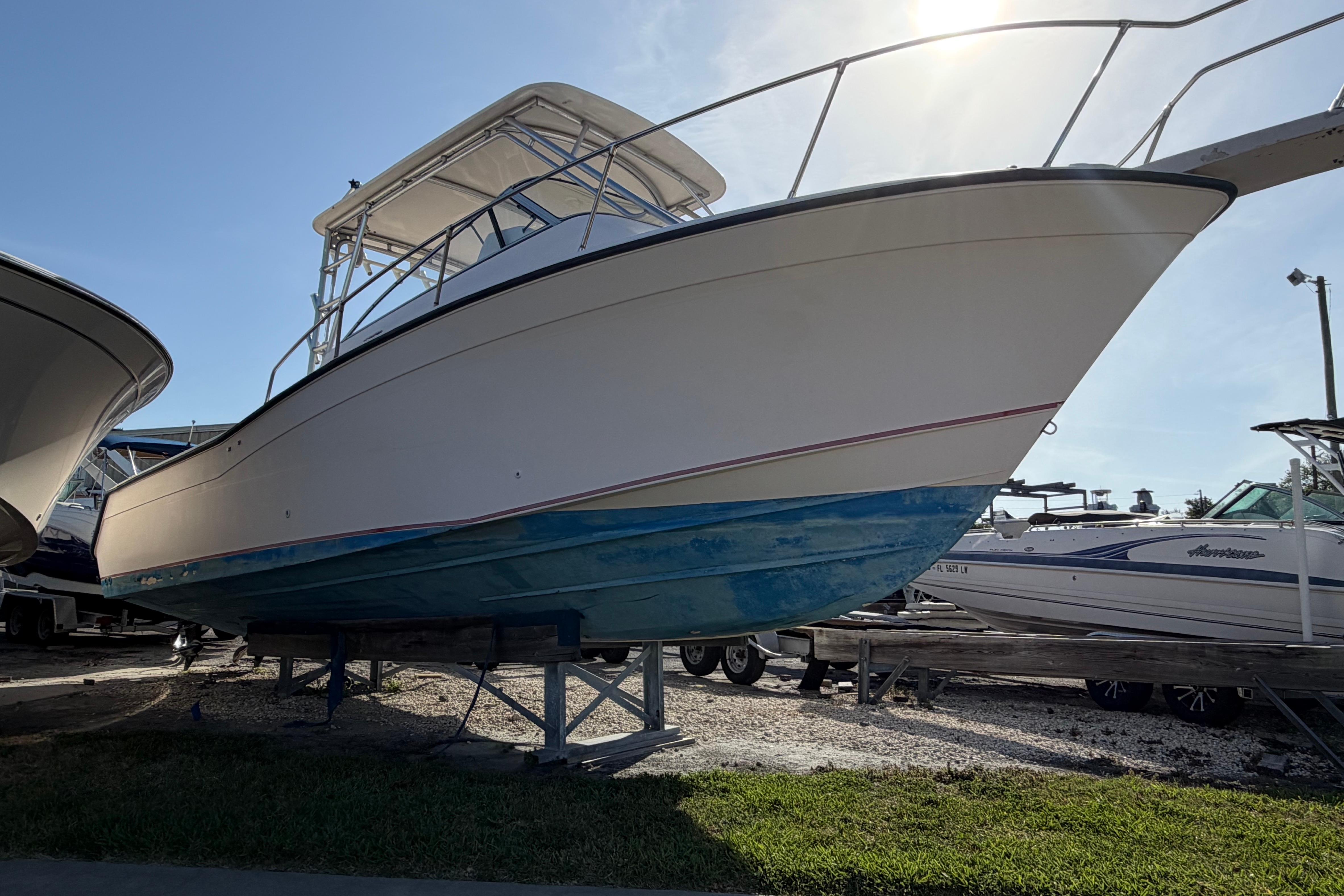 1996 Grady-White Marlin 300 boat on display, elevated on stands, under clear sky.