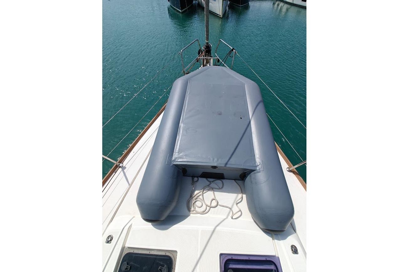 2016 Beneteau Oceanis 45 yacht deck with inflatable dinghy, docked in calm waters.