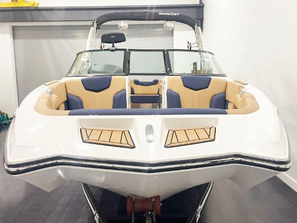 2022 MasterCraft NXT24 boat with tan and blue interior, displayed indoors.