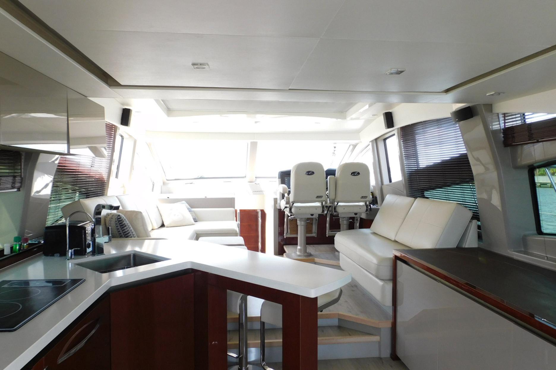 Luxurious interior of 2019 Sea Ray L550 yacht with modern seating and kitchen area.
