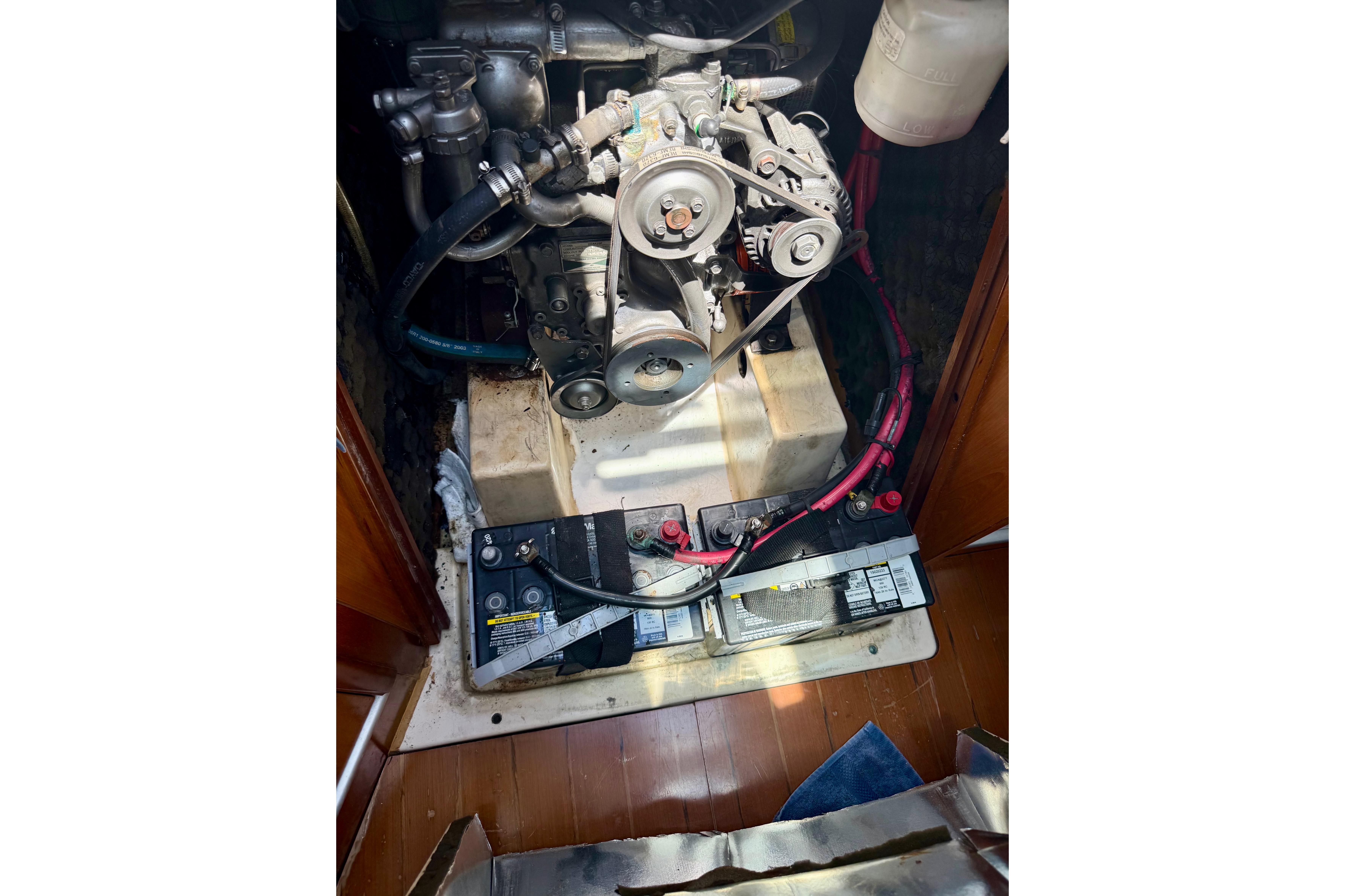 Engine compartment of a 2002 Beneteau Oceanis Clipper 311 sailboat, featuring batteries and mechanical components.