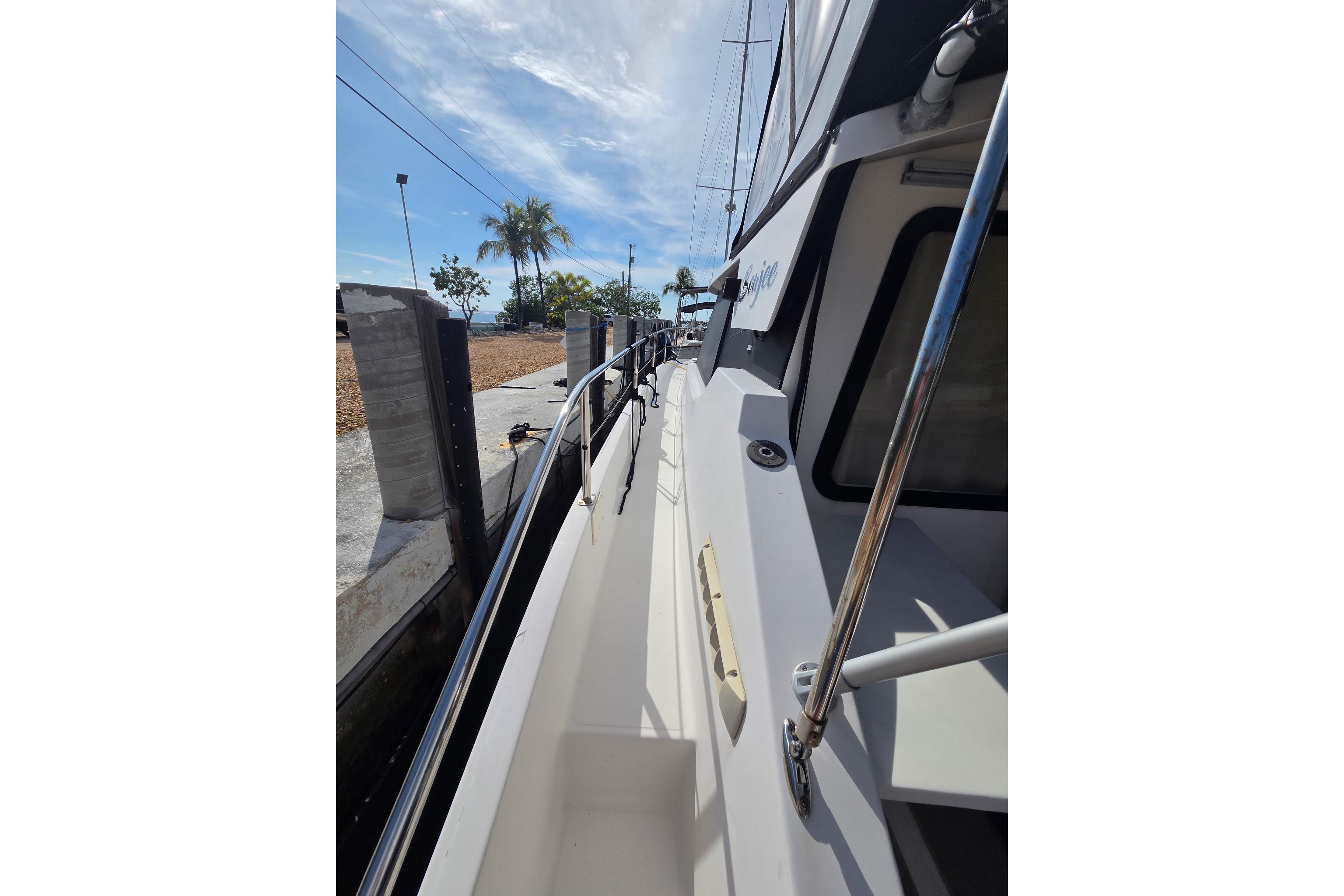 Side view of 2000 Fountaine Pajot Maryland 37 yacht docked under a sunny sky.
