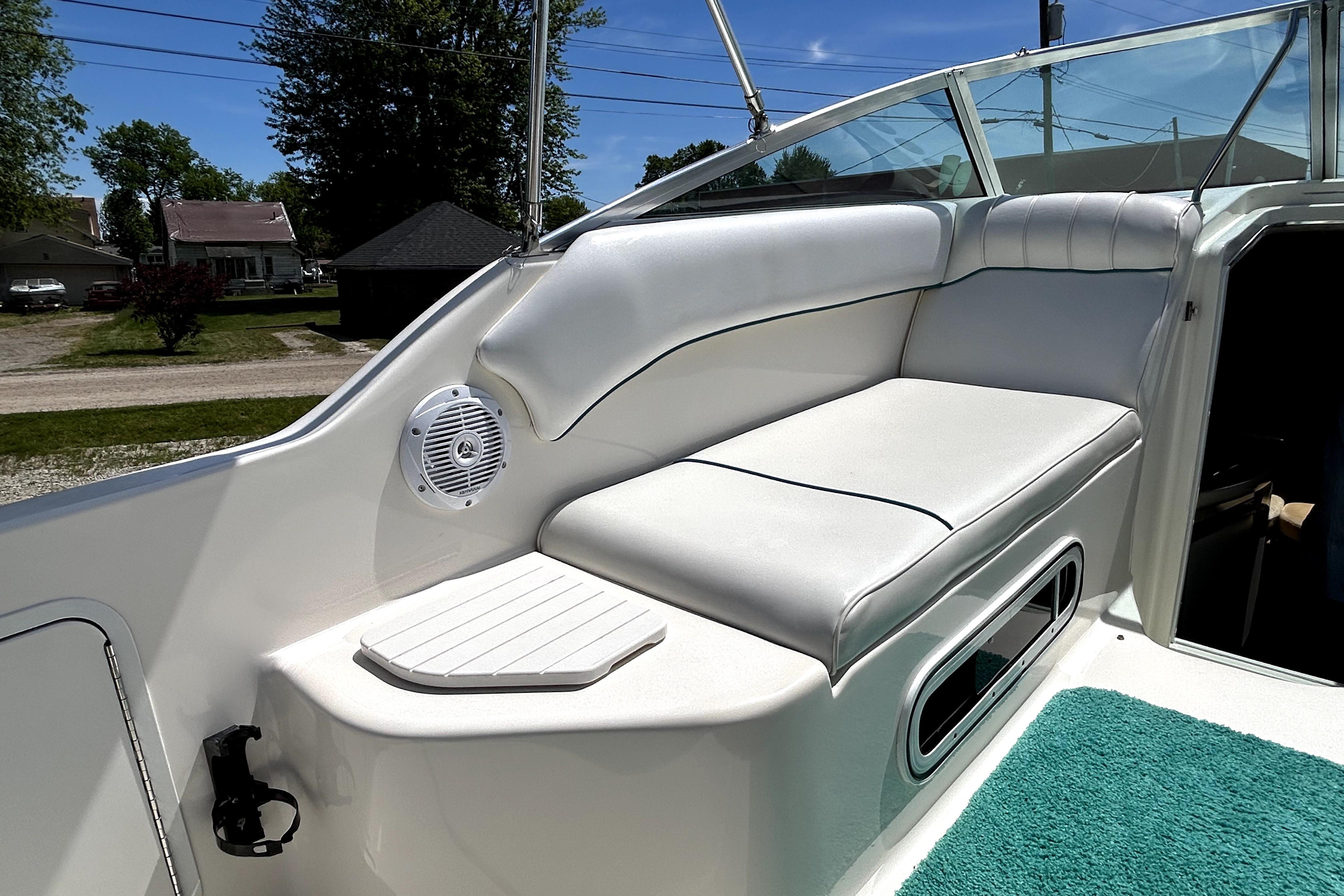 1995 Sea Ray 250 Sundancer boat interior with white seating and speaker.