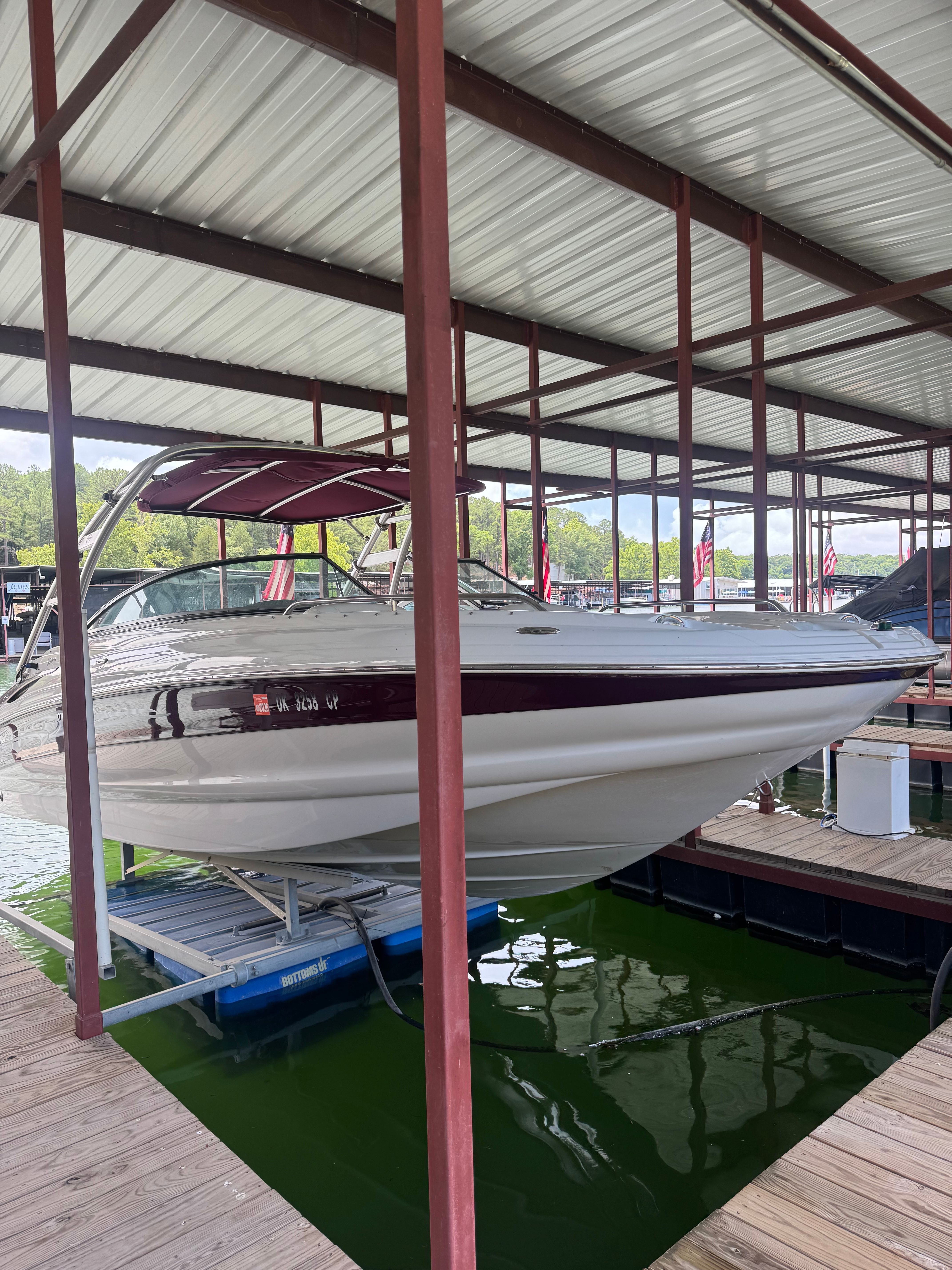 A 2008 Crownline 252EX boat is docked under a covered shelter.