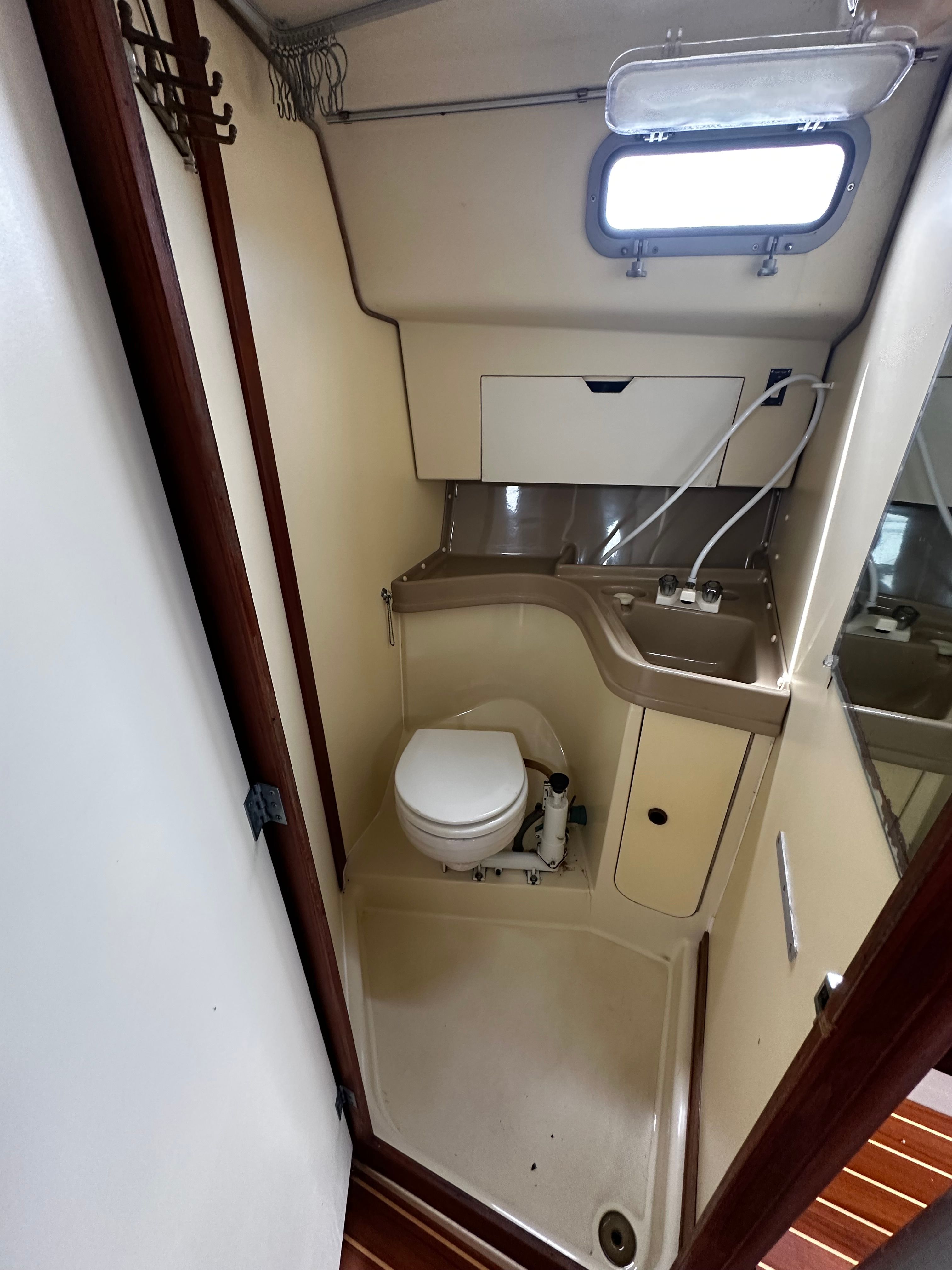 The image shows the bathroom of a 1984 Pearson 303 with a toilet and sink.