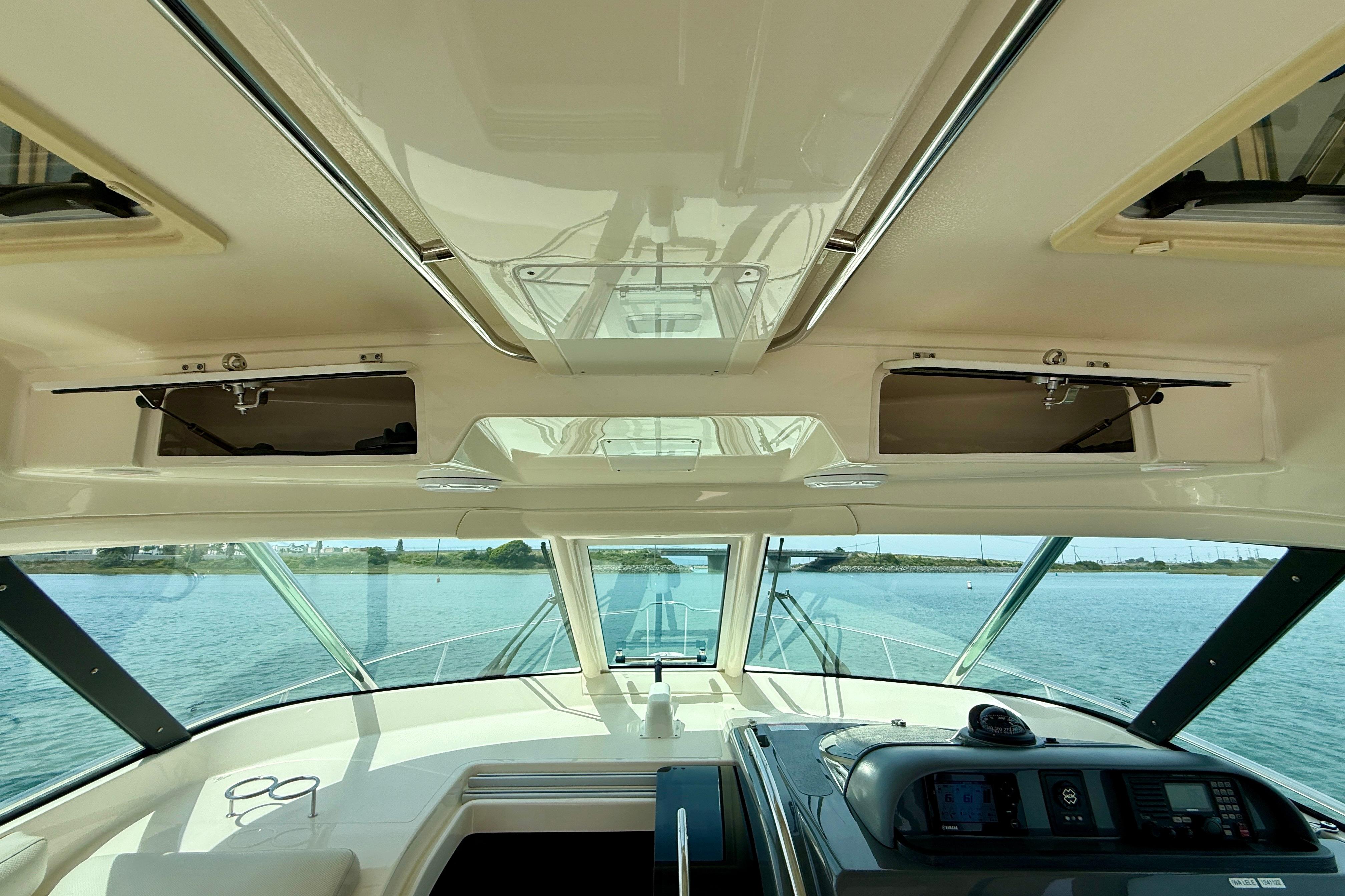 Interior view of 2012 Pursuit OS 345 Offshore boat, showcasing helm and open storage compartments.