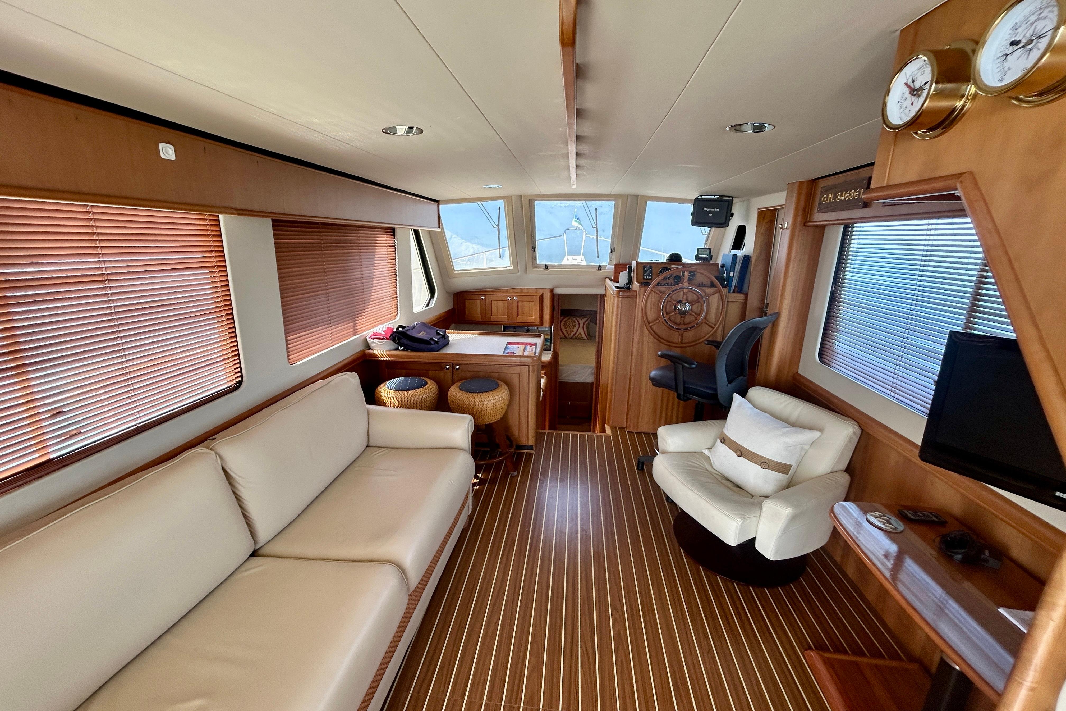 Interior of 2006 Mainship 34 Trawler with wooden decor and comfortable seating.