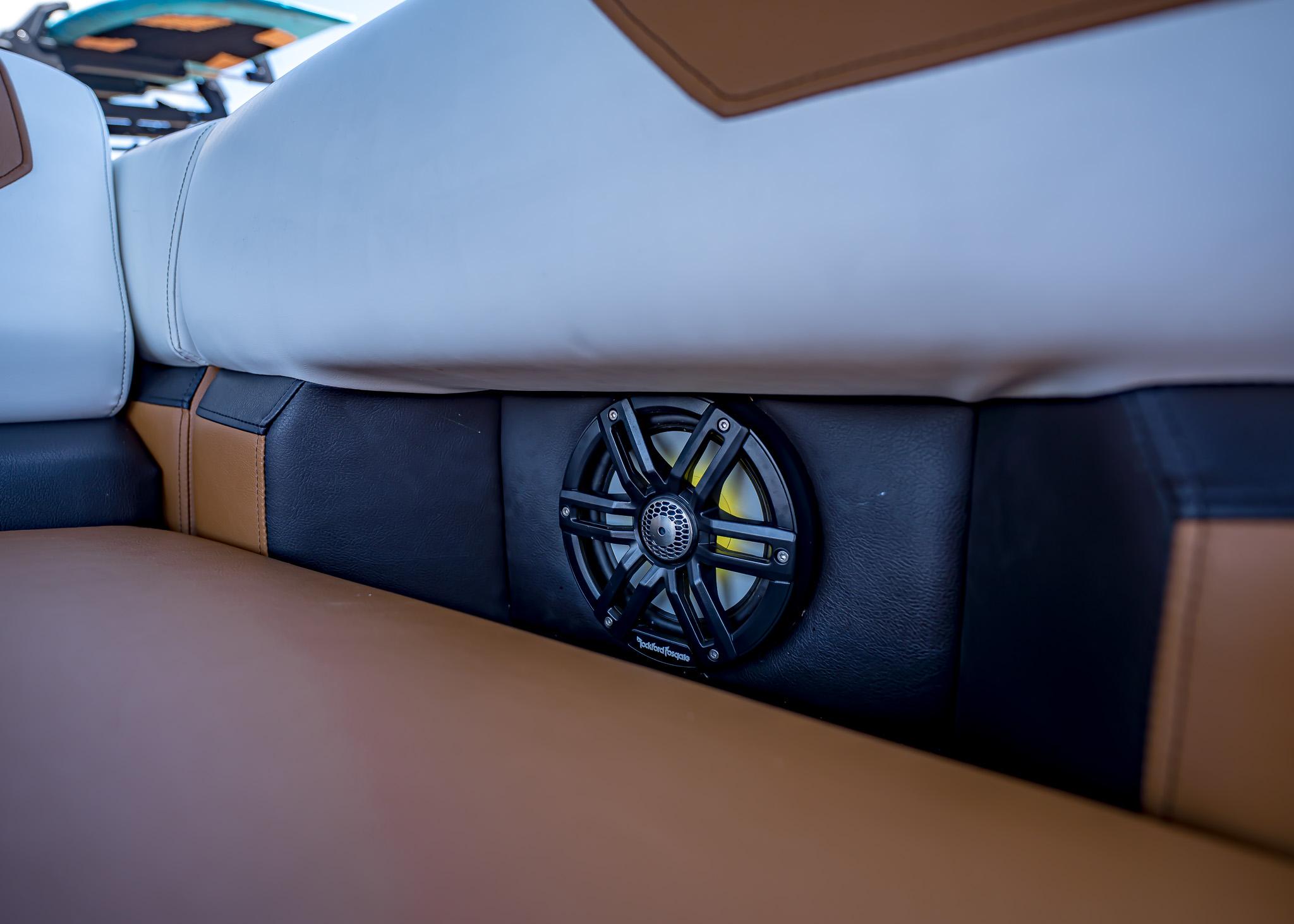 Boat interior with brown and white seating, featuring a built-in speaker. Paradigm 236, 2025 model.