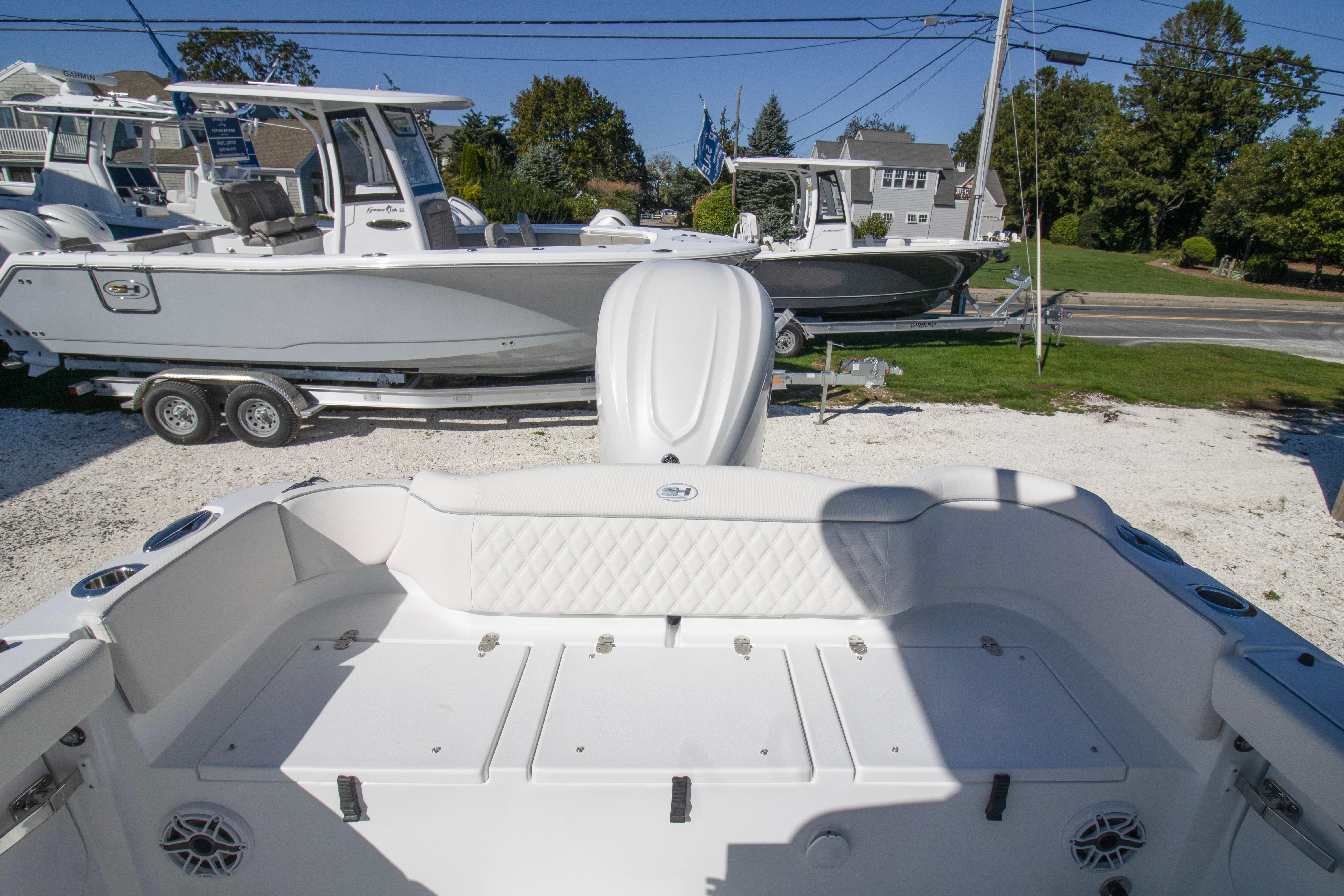 2026 Sea Hunt Ultra 255 SE boat interior with seating and storage, parked outdoors.