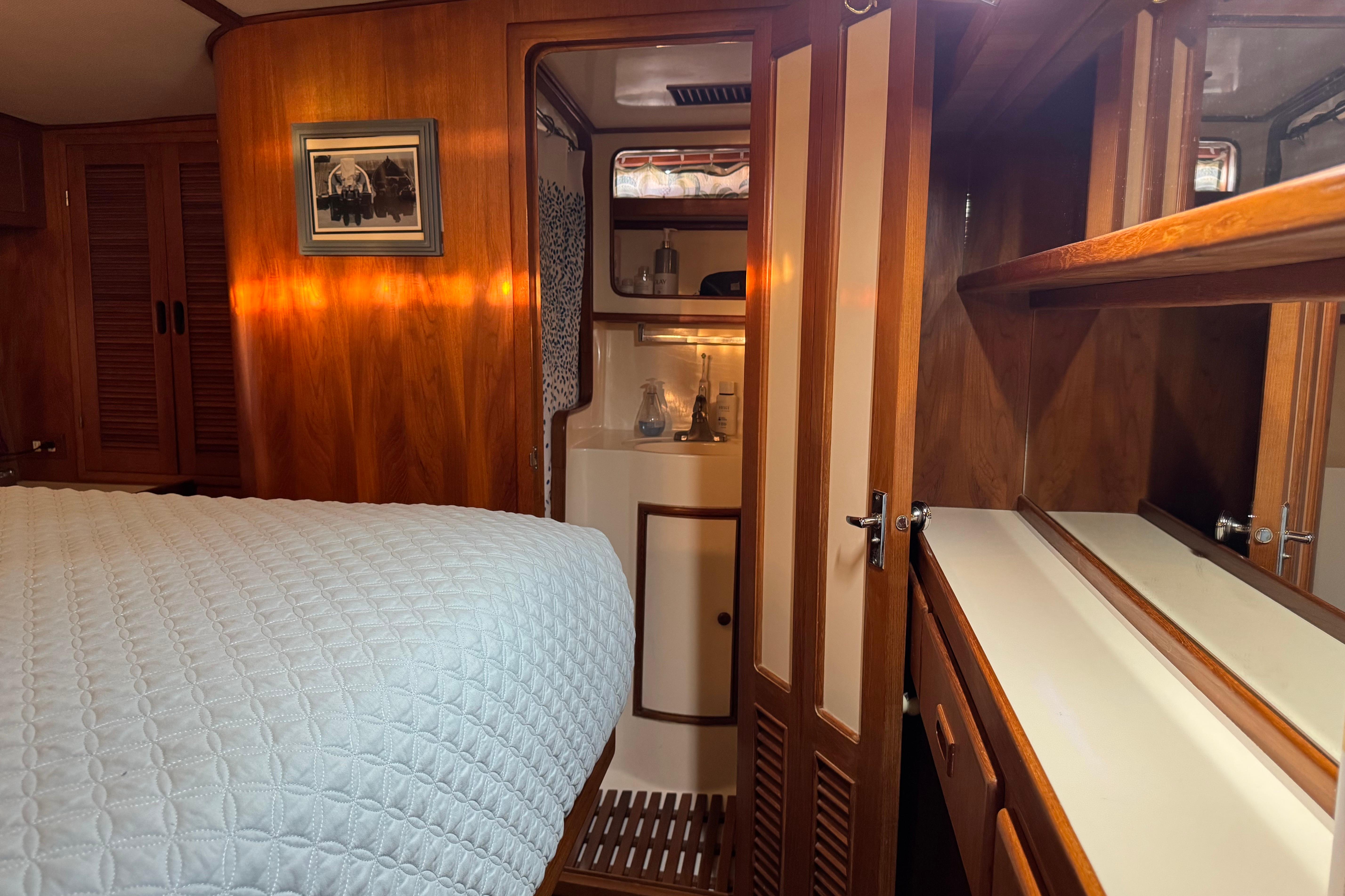Cozy 1987 President 37 yacht cabin with wood paneling and a neatly made bed.