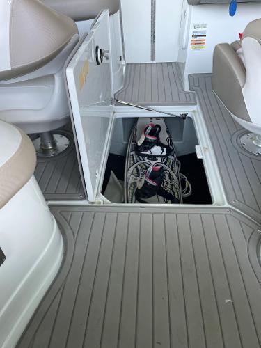 2019 Crownline E255 boat interior with open storage compartment and wakeboard gear.