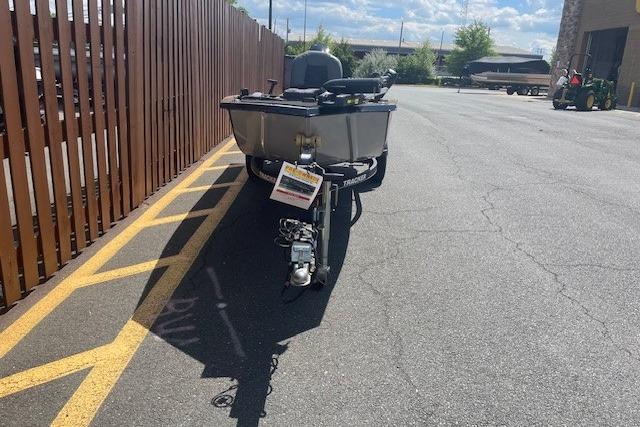 2019 Tracker Panfish 16 boat parked on asphalt near a wooden fence under a sunny sky.