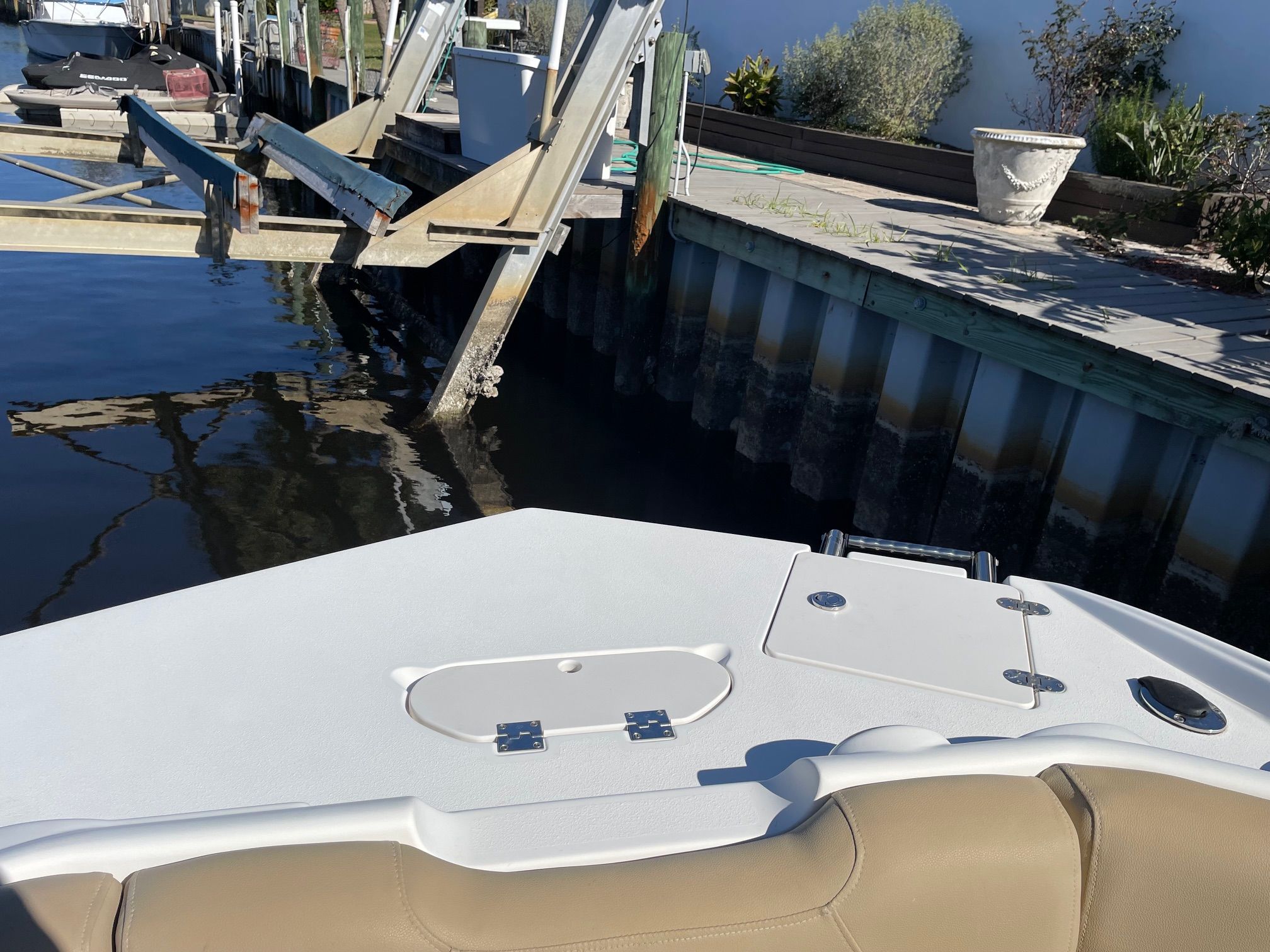 The boat is docked with plants visible in the background.