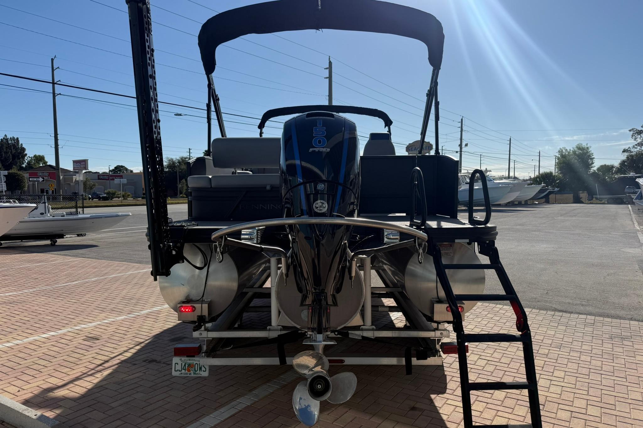 2024 Bennington SSB-SPS pontoon boat with outboard motor, parked on brick pavement.