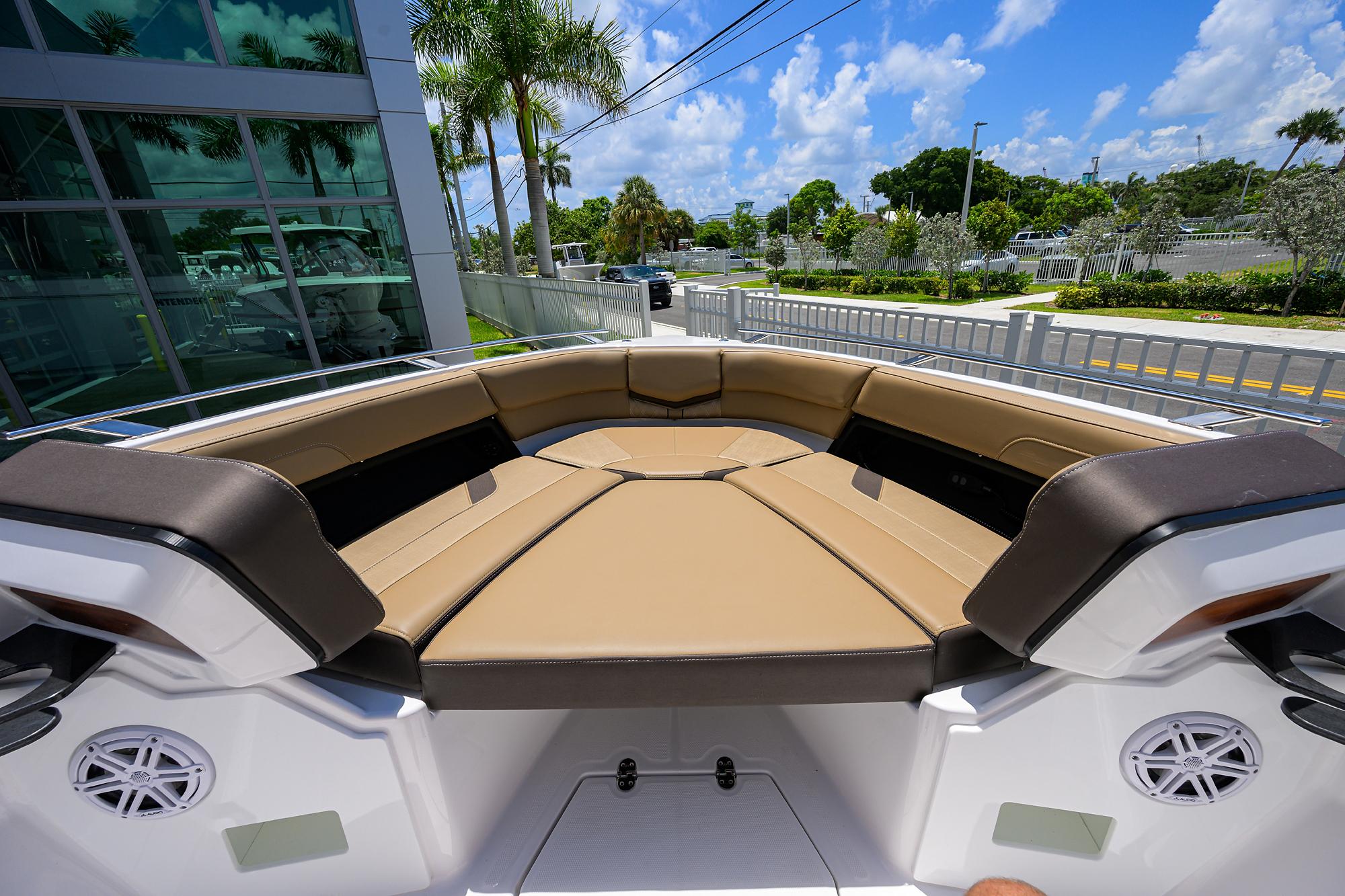 2026 Monterey Elite 27 OB boat with tan seating, outdoor view, and palm trees.