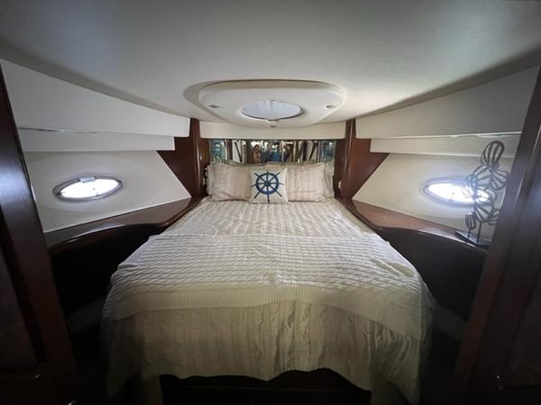 Luxurious bedroom in a 2009 Ovation 52 yacht with nautical decor.