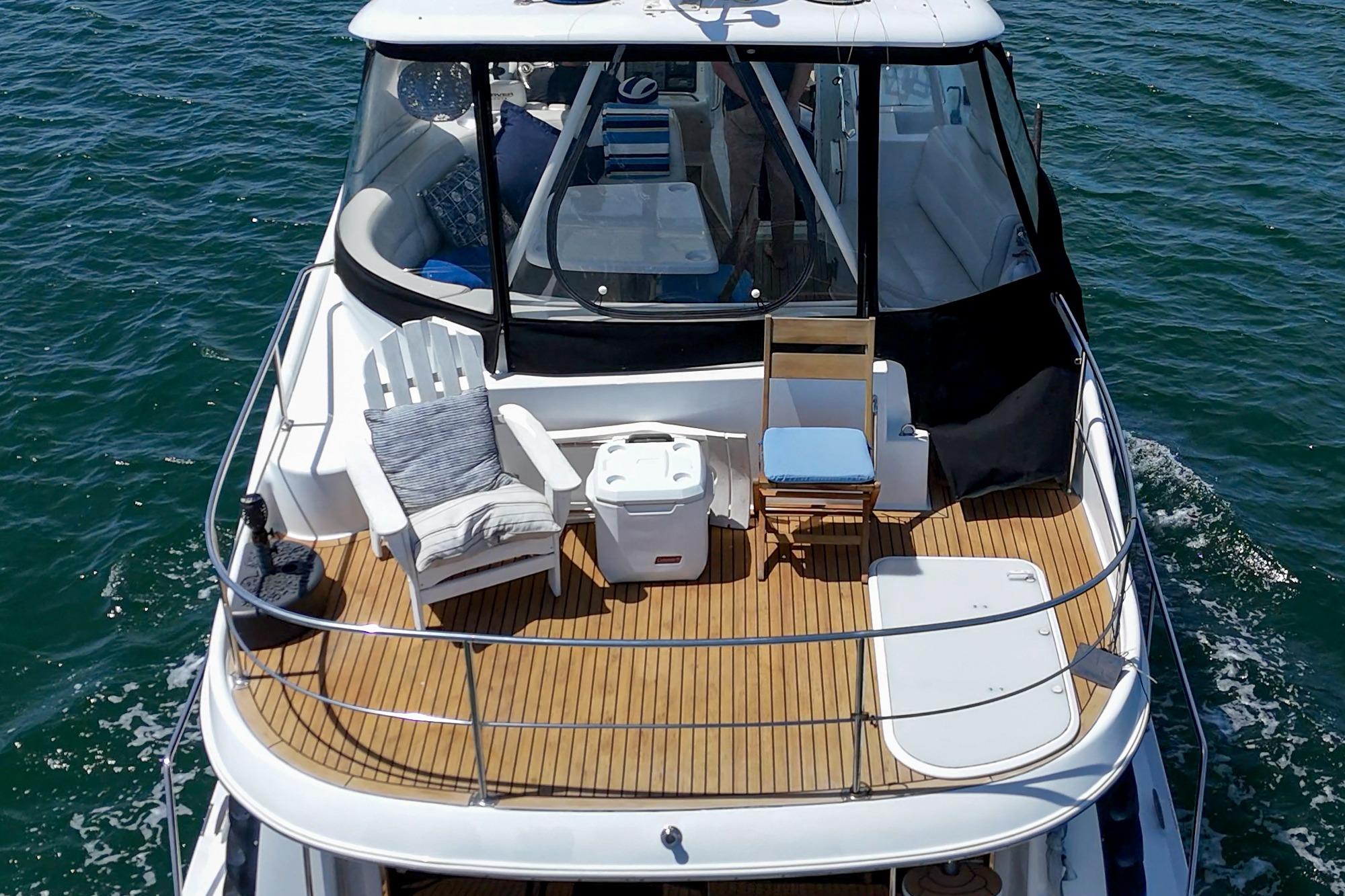 2003 Carver 530 Voyager Pilothouse yacht with spacious deck and seating on open water.