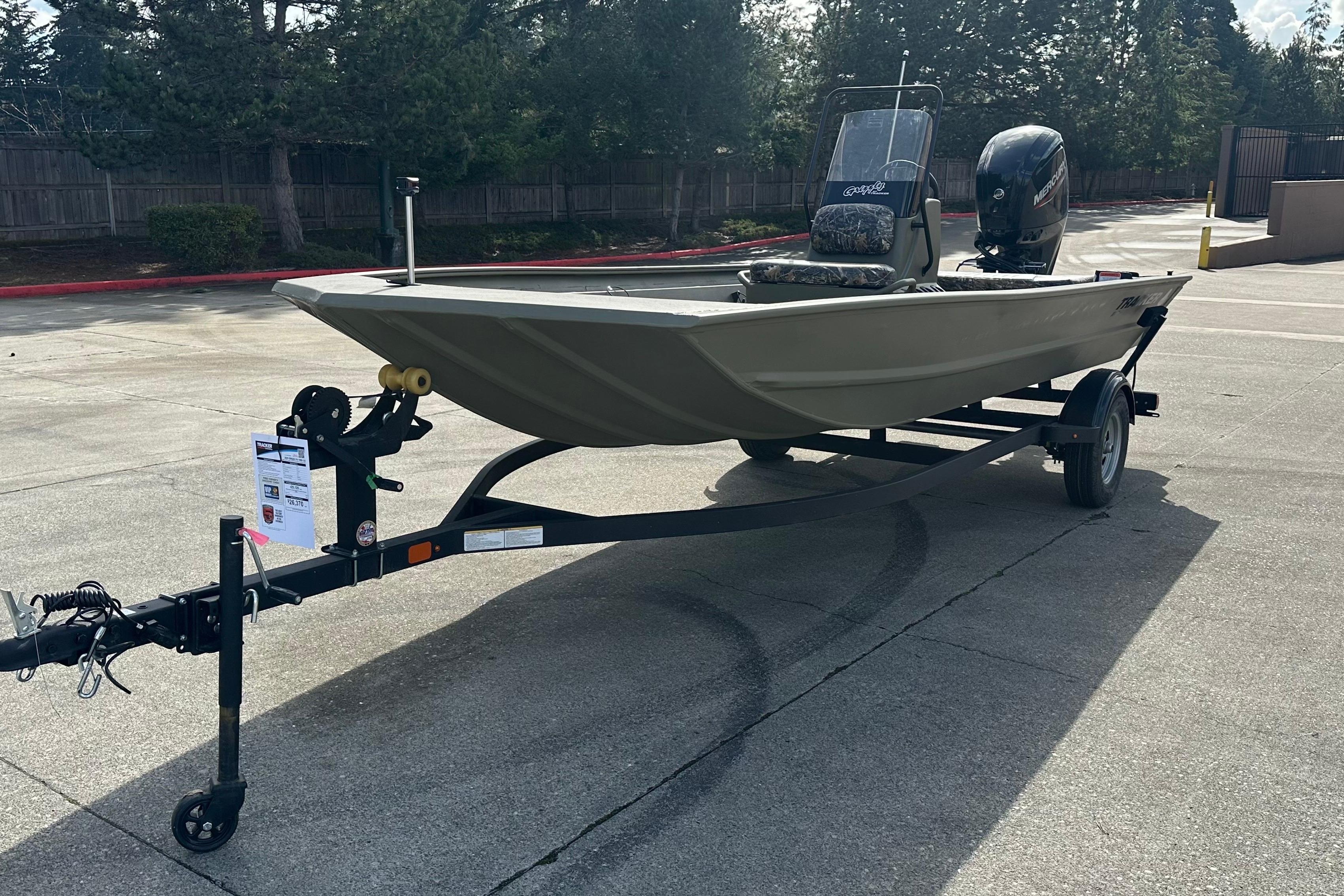 2026 Tracker Grizzly 1860 CC boat on trailer, parked outdoors.
