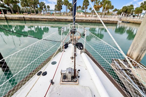 Bow of 1989 Concordia 52 sailboat docked in calm marina with palm trees.