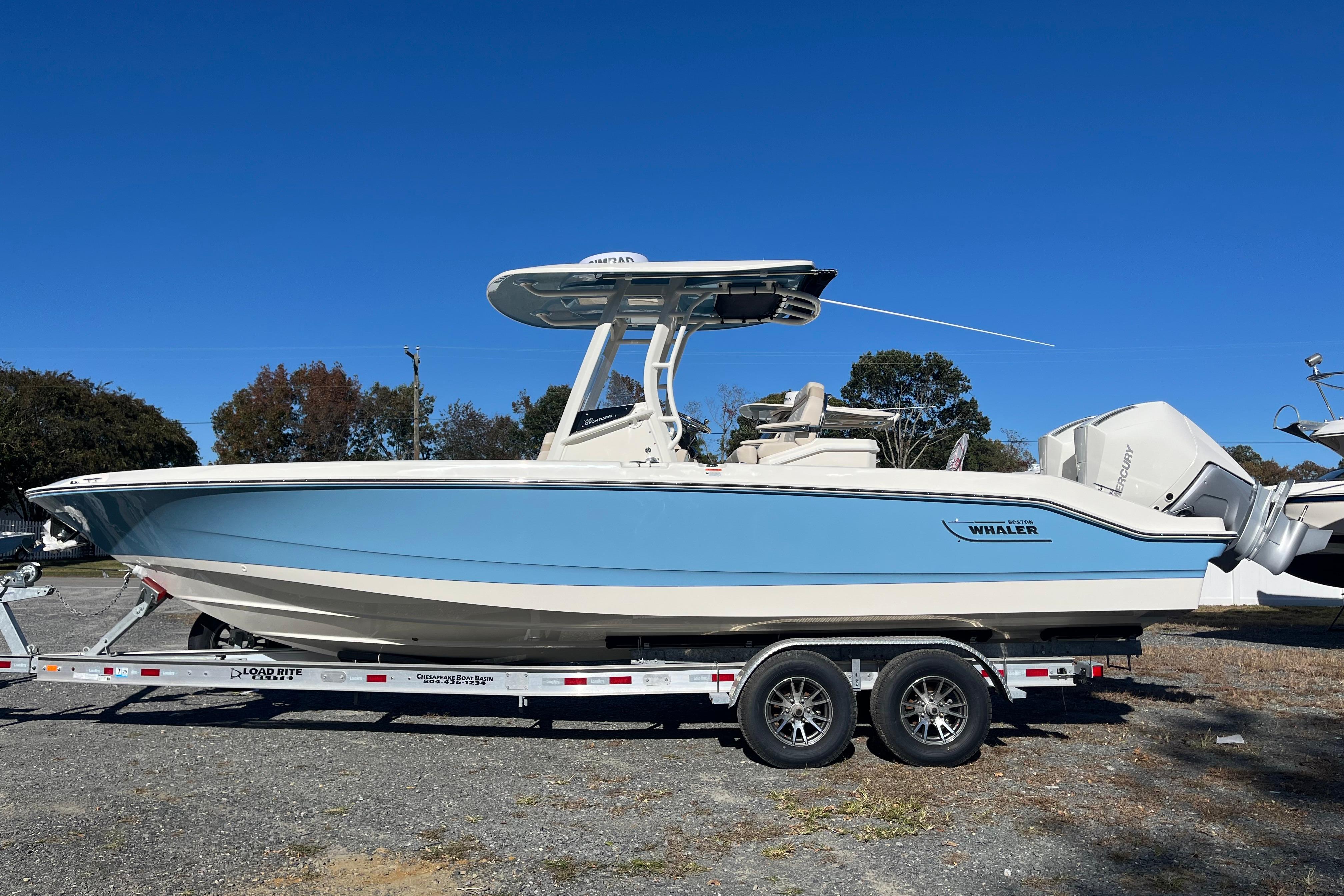 2026 Boston Whaler 280 Dauntless boat on trailer, side view, clear blue sky.