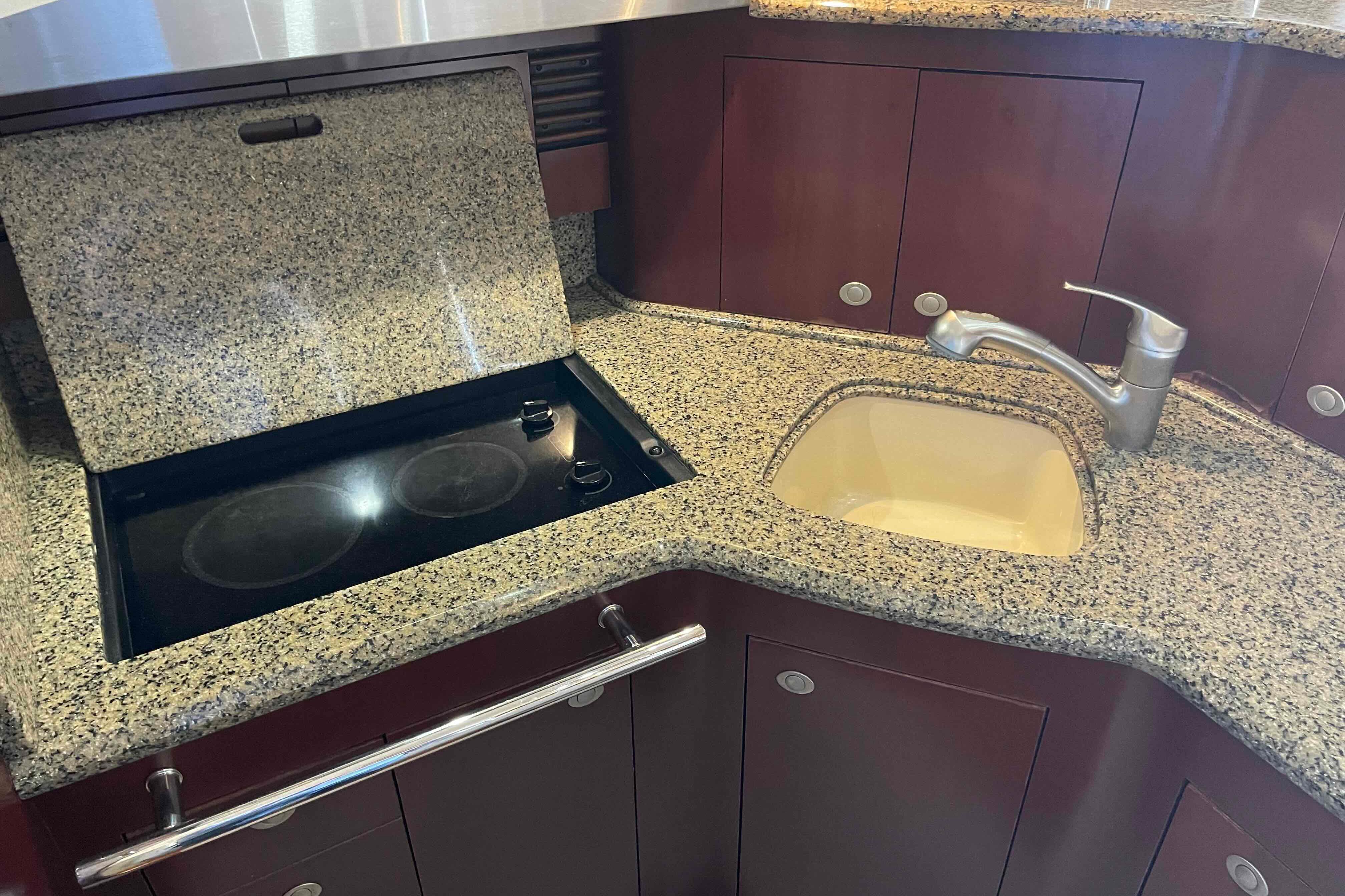 Granite countertop with stove and sink in 2005 Sea Ray 420 Sedan Bridge yacht.