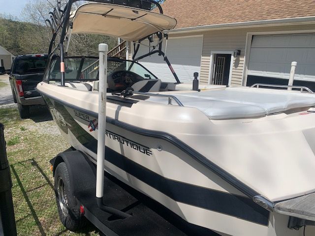 2001 Correct Craft Super Air Nautique on trailer in front of garage.