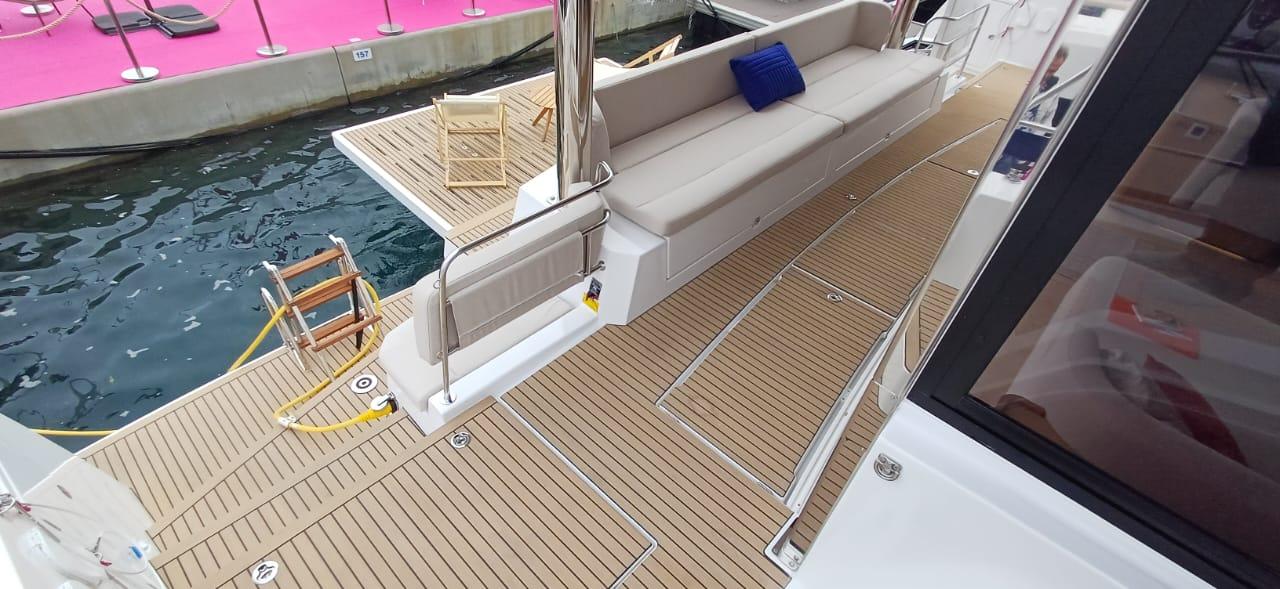 2025 Bali 5.8 yacht deck with seating, docked by the water.