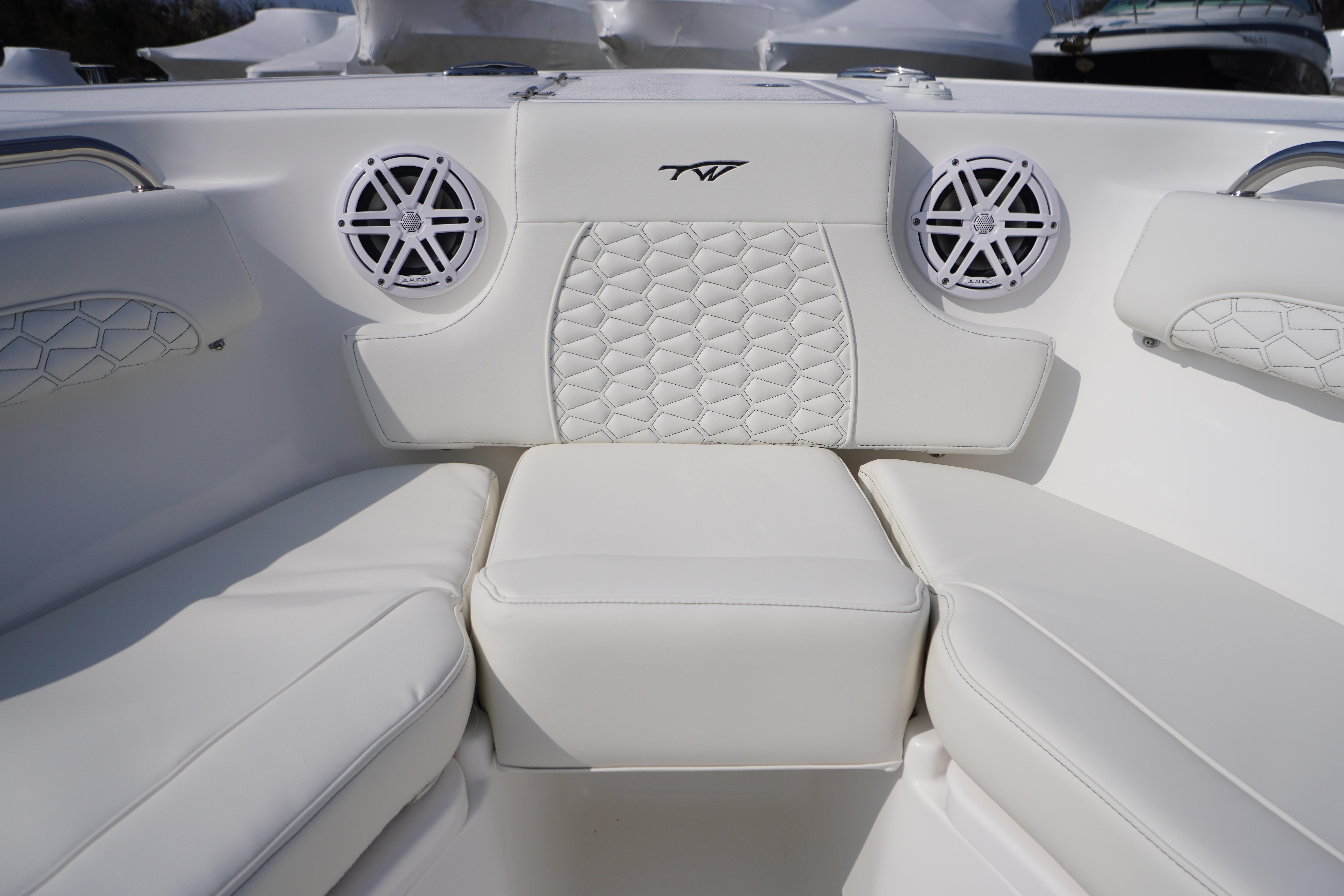 Luxurious seating on 2026 Tidewater 232 LXF boat with stylish white upholstery and speakers.