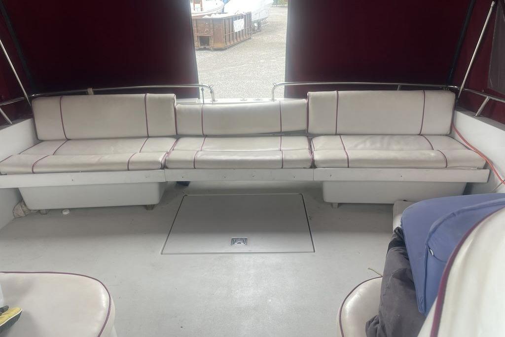 1987 Chris-Craft 332 Amerosport boat interior with white seating and maroon canopy.