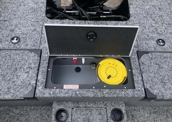 2025 Tracker Targa V18 Combo boat storage compartment with open lid and yellow container.