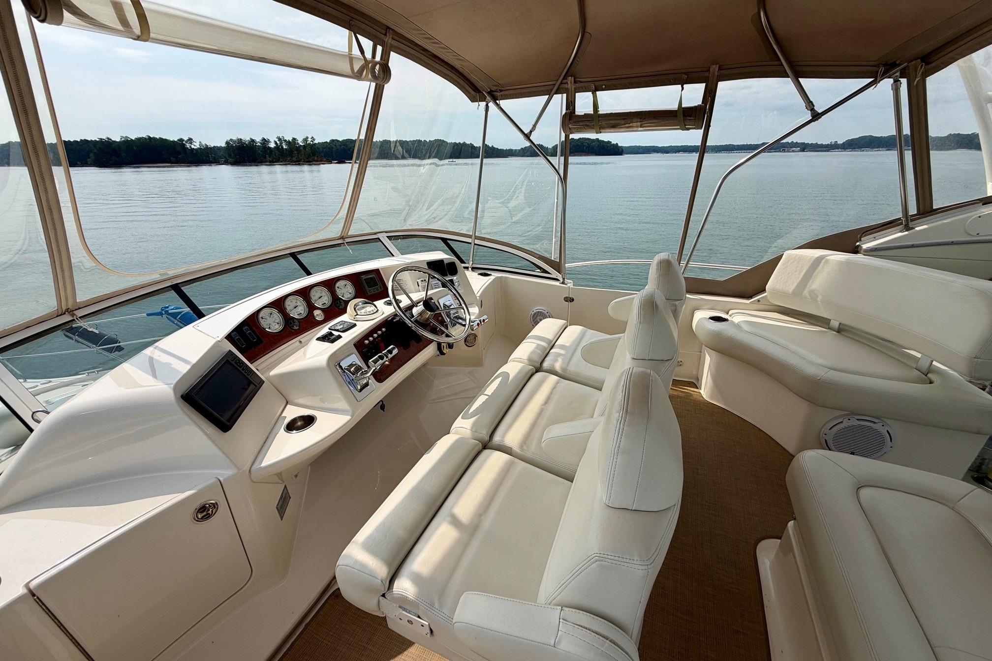 2004 Silverton 39 Motor Yacht interior with helm, white seating, and panoramic lake view.