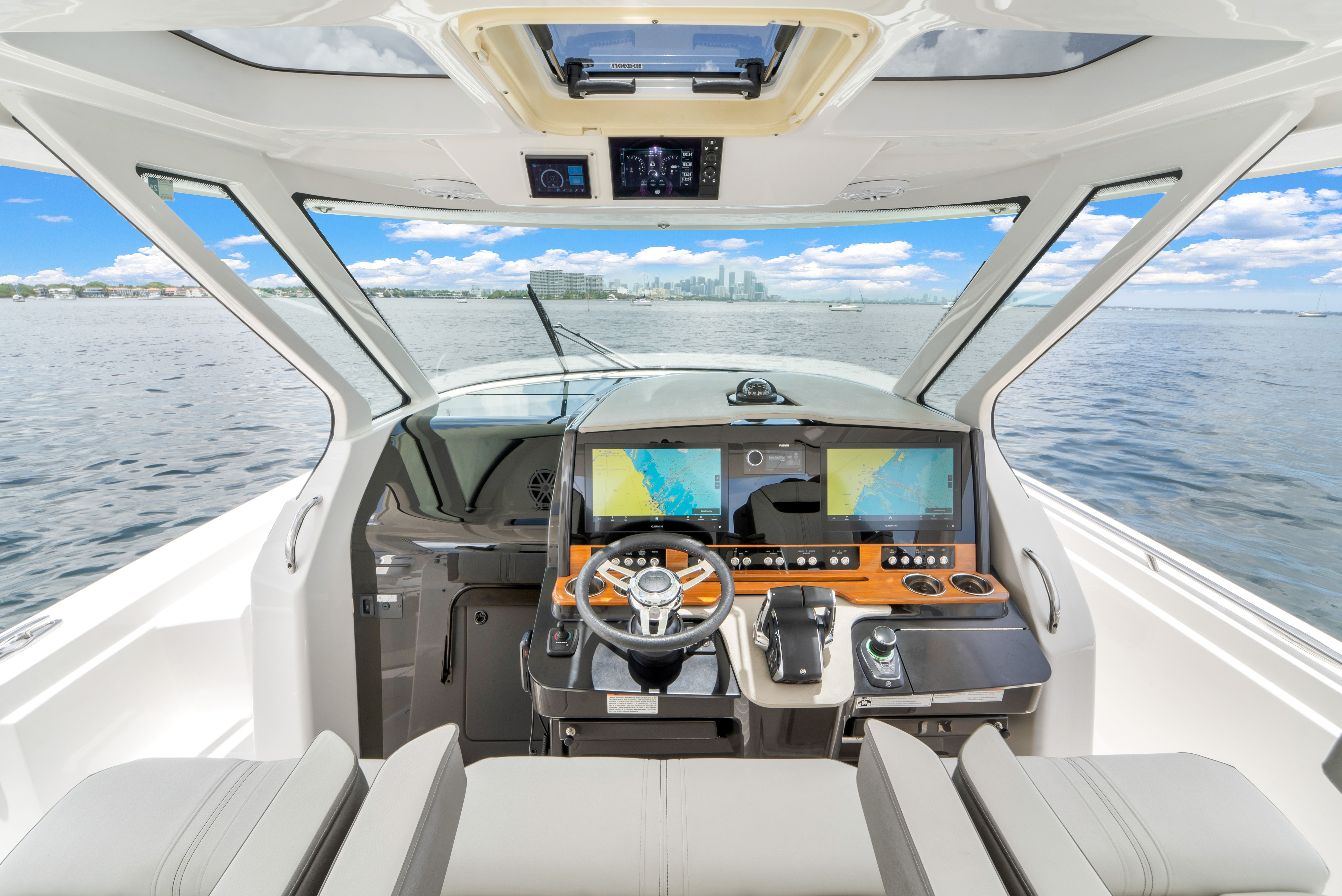 The cockpit of a 2023 Tiara Yachts 38 LS with a modern helm and panoramic water view.