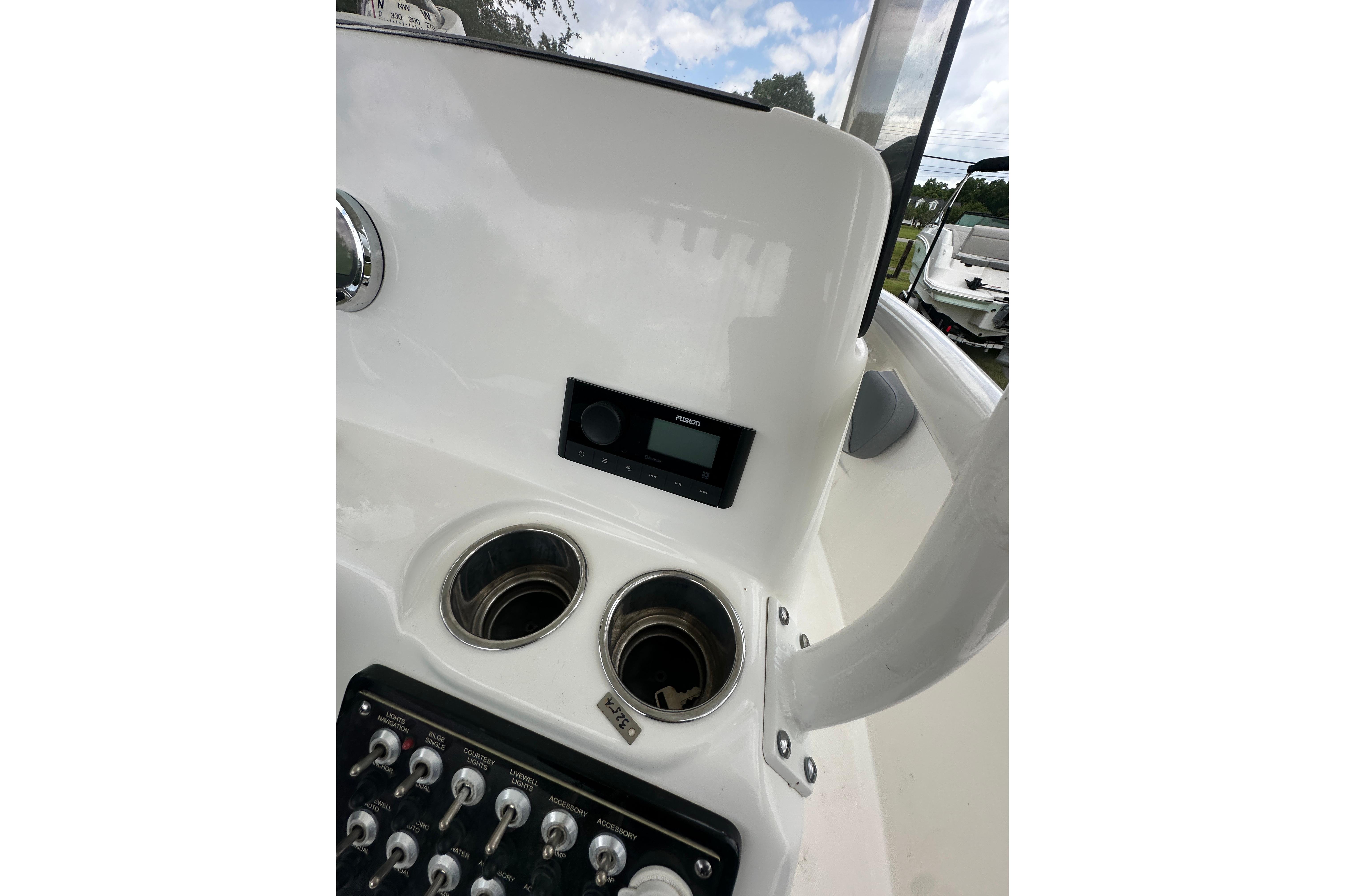 Control panel of 2023 NauticStar 2102 Legacy boat with cup holders and switches.