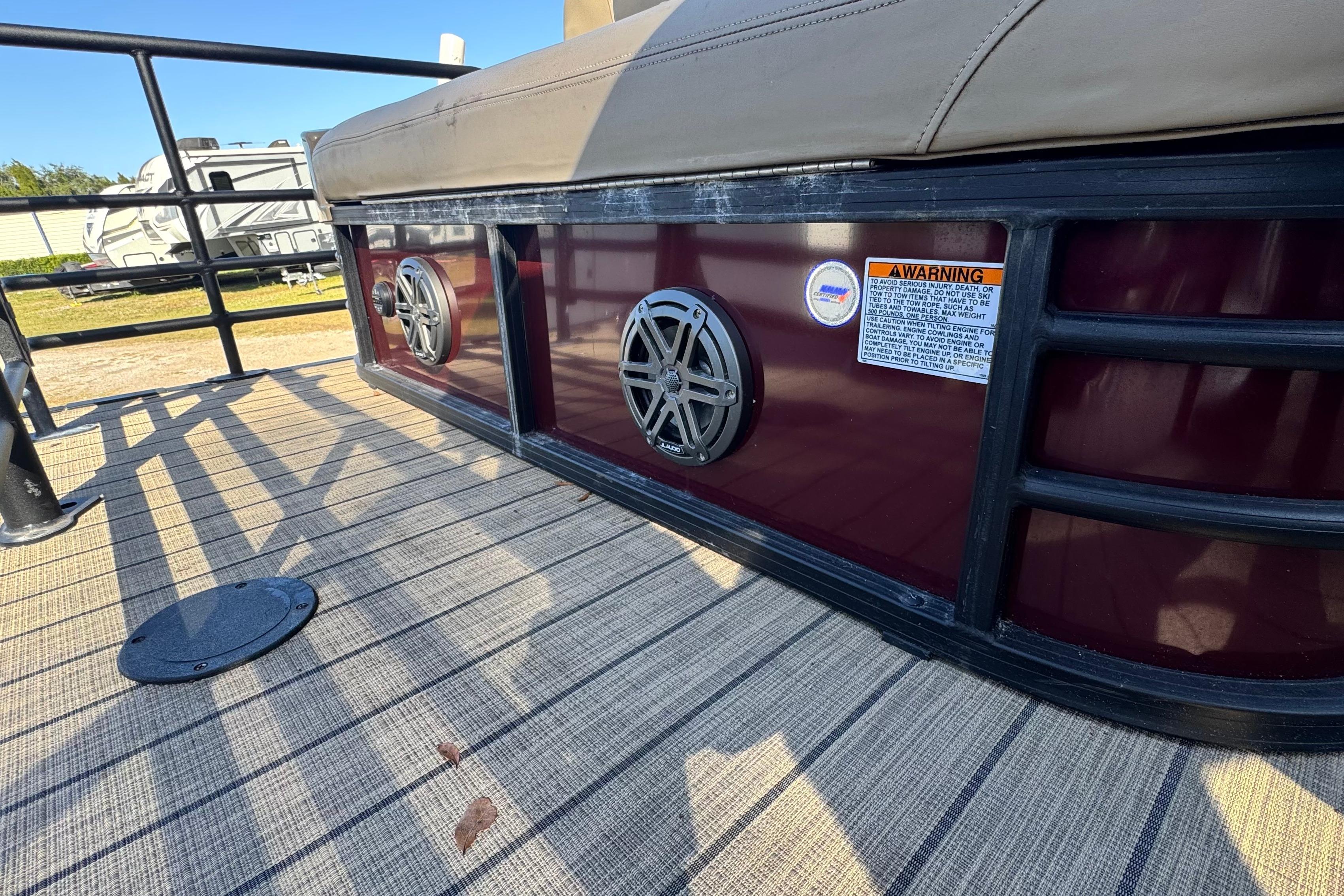 2023 Sylvan L5 CLZ boat deck with speakers and warning label.