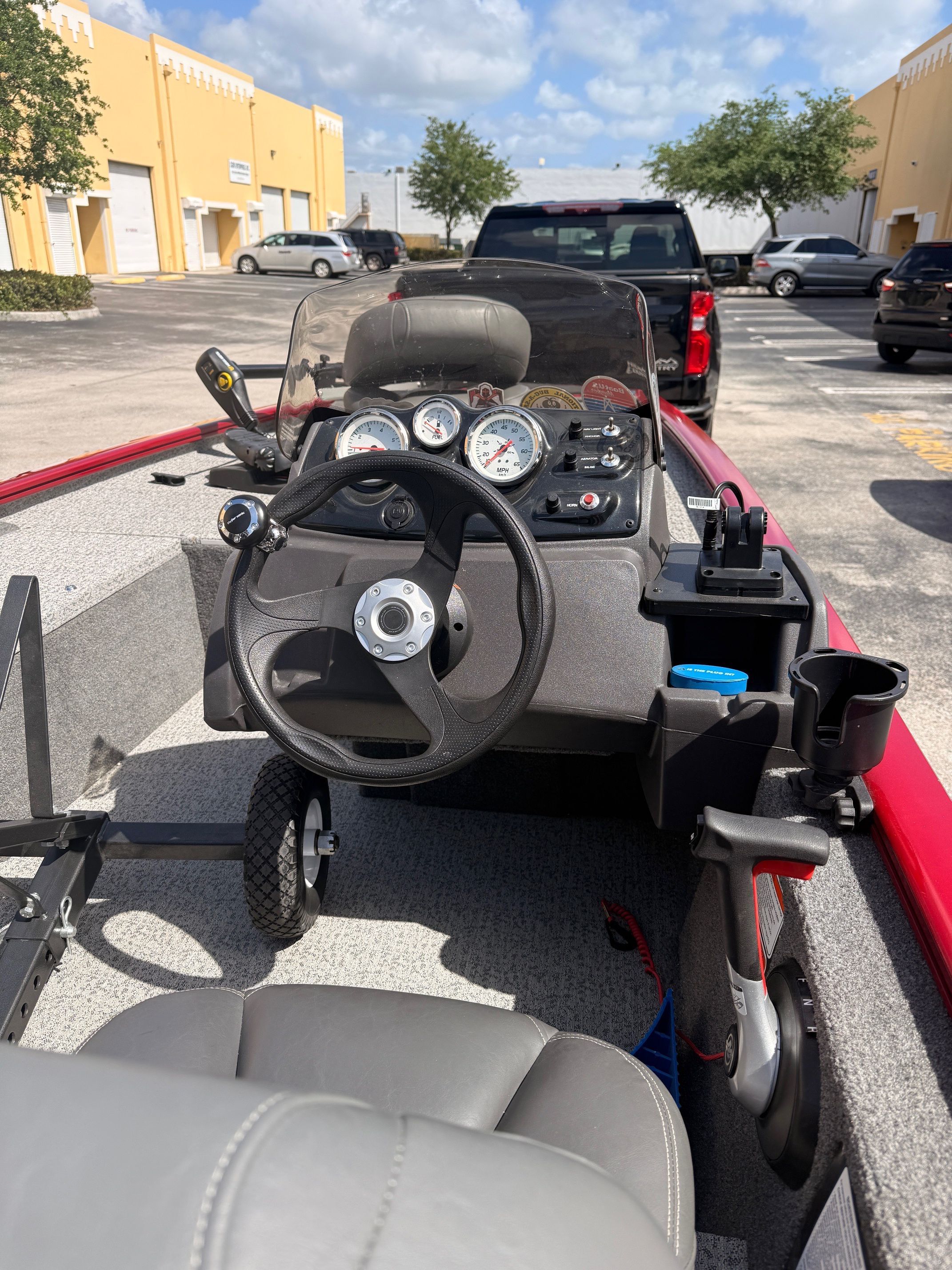 The image shows the cockpit of a Tracker Pro 170 boat with steering wheel and gauges.