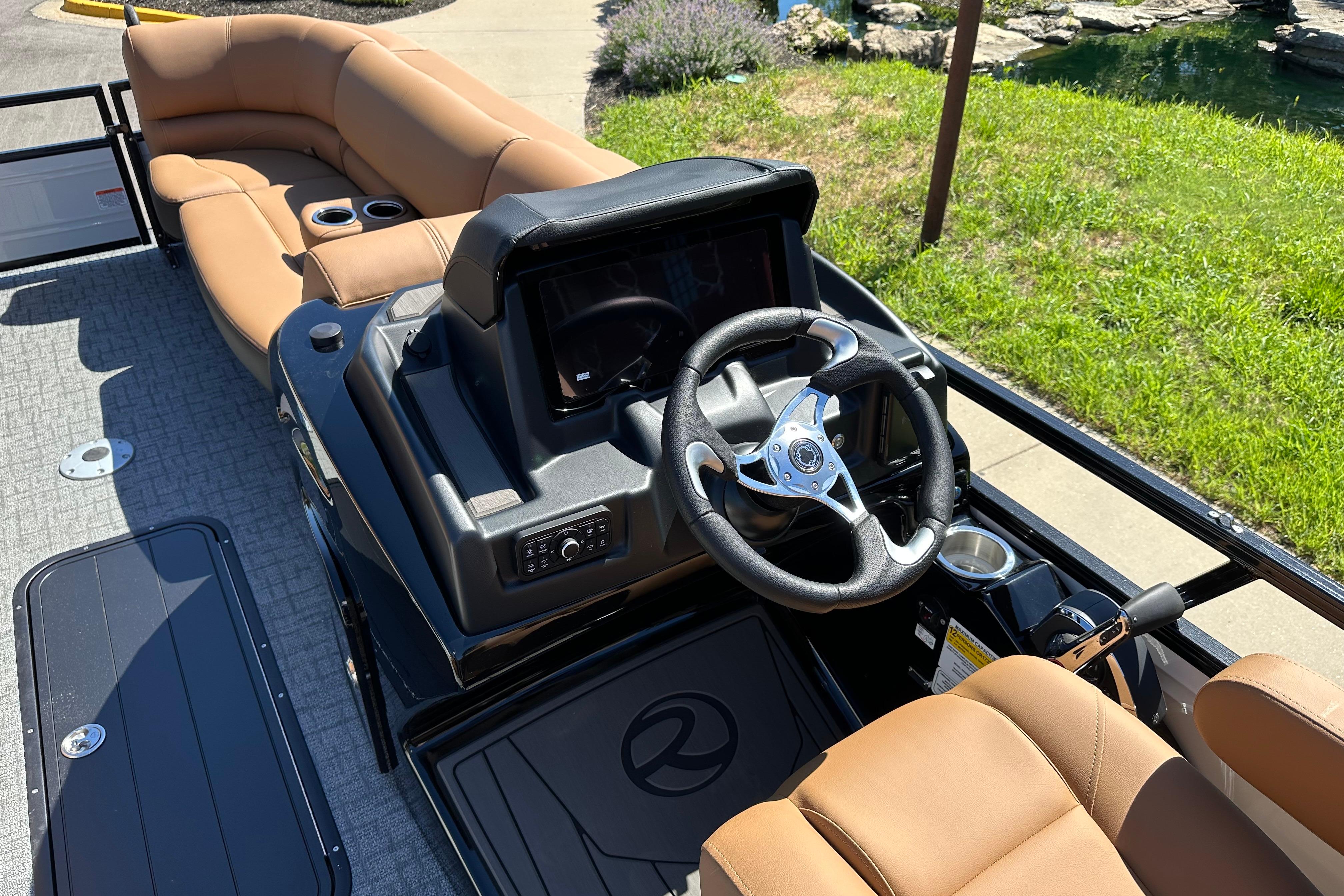 2026 Regency 230 DL boat interior with tan seating and modern steering console.
