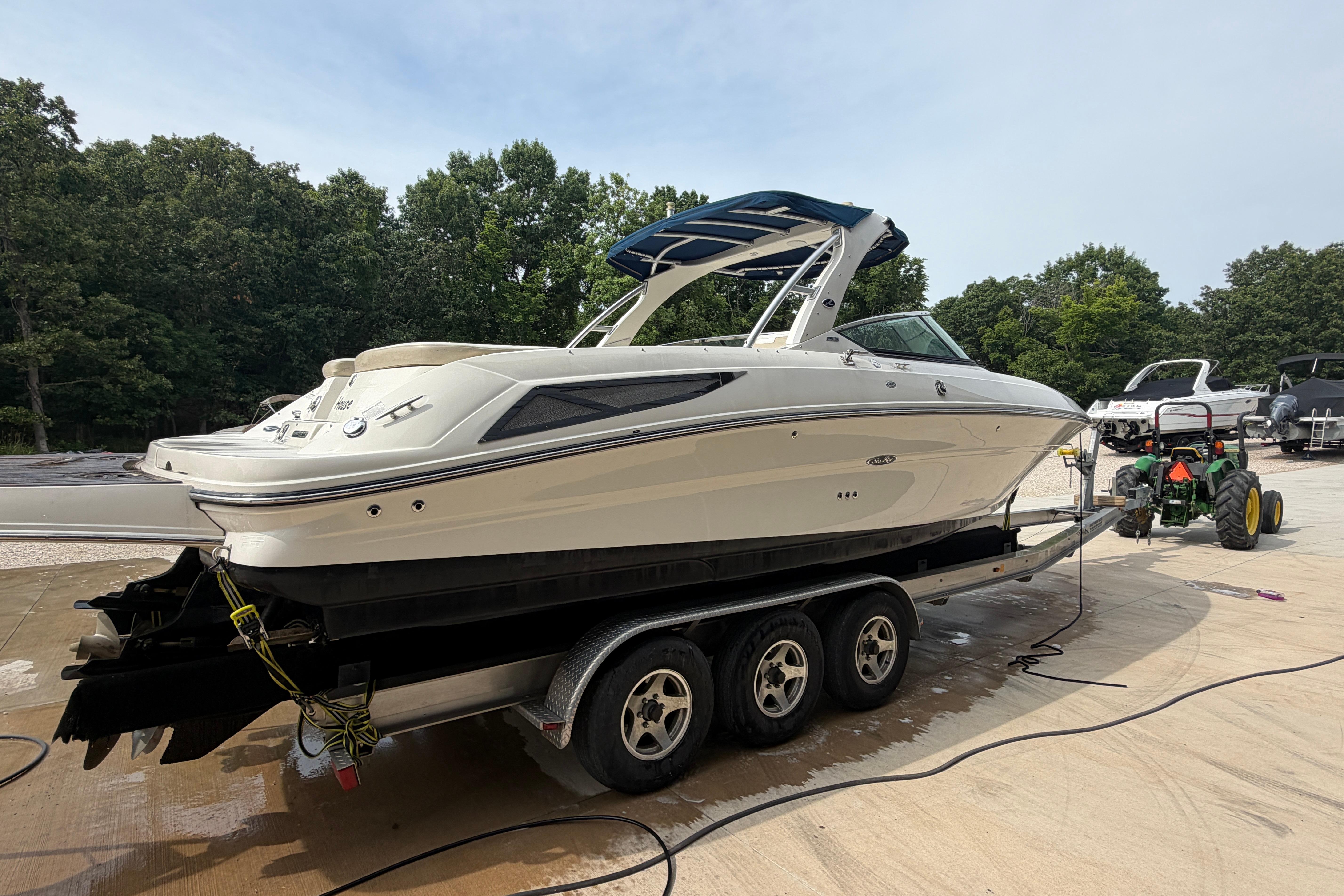 2013 Sea Ray 300 SLX boat on trailer, parked outdoors near trees.