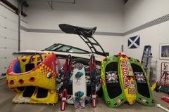 A 2017 Yamaha AR195 boat is in a garage, surrounded by colorful water sports gear.