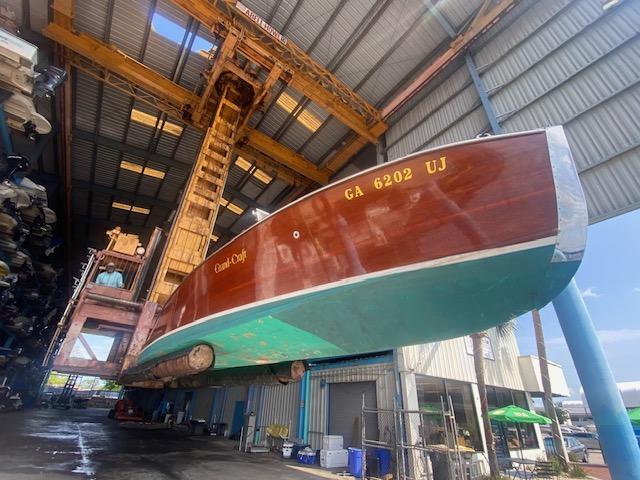 Grand Craft Classic Runabout 2000 in a boatyard, suspended for maintenance or storage.