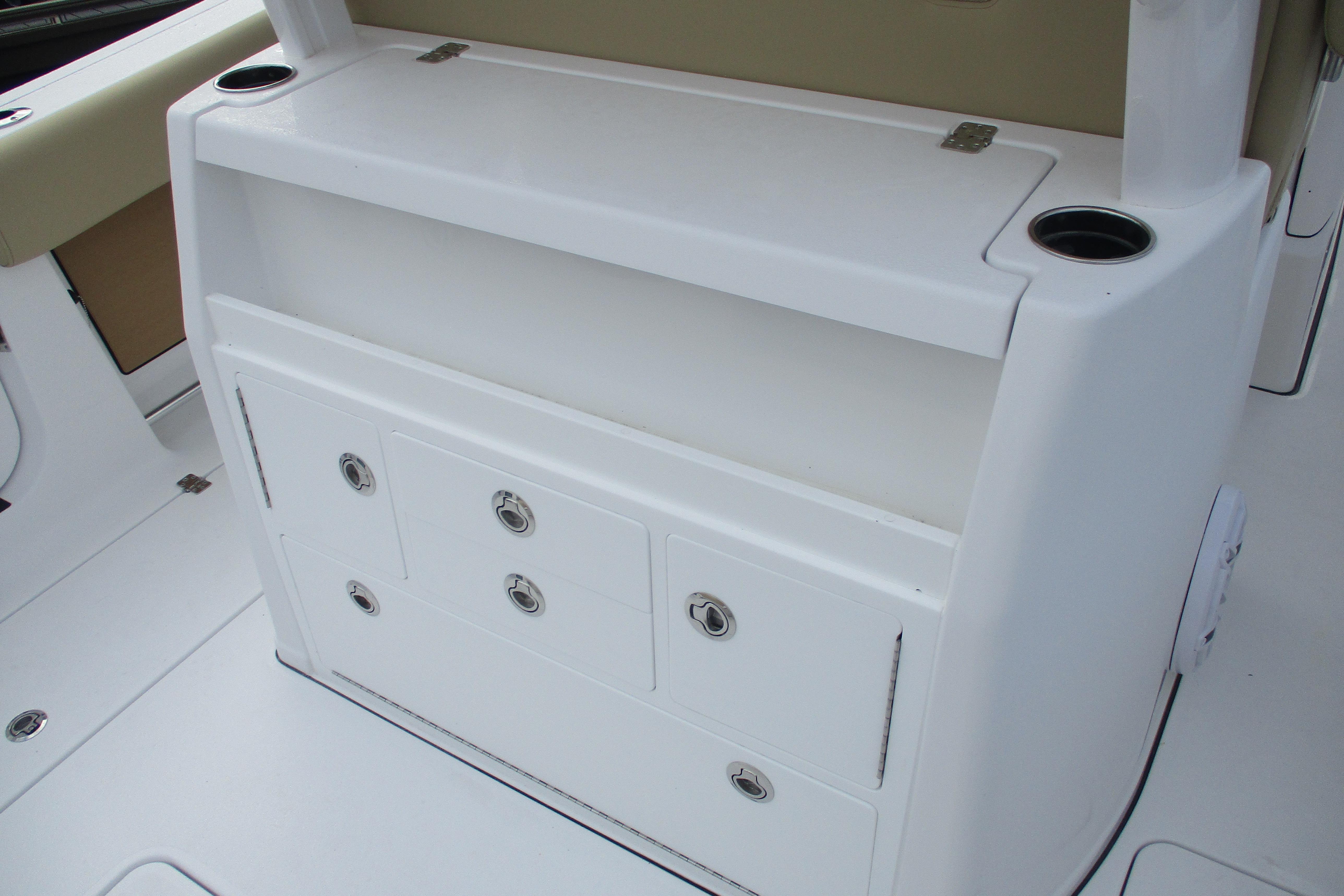 2026 Sportsman Open 302 Center Console storage compartment with cup holders and drawers.