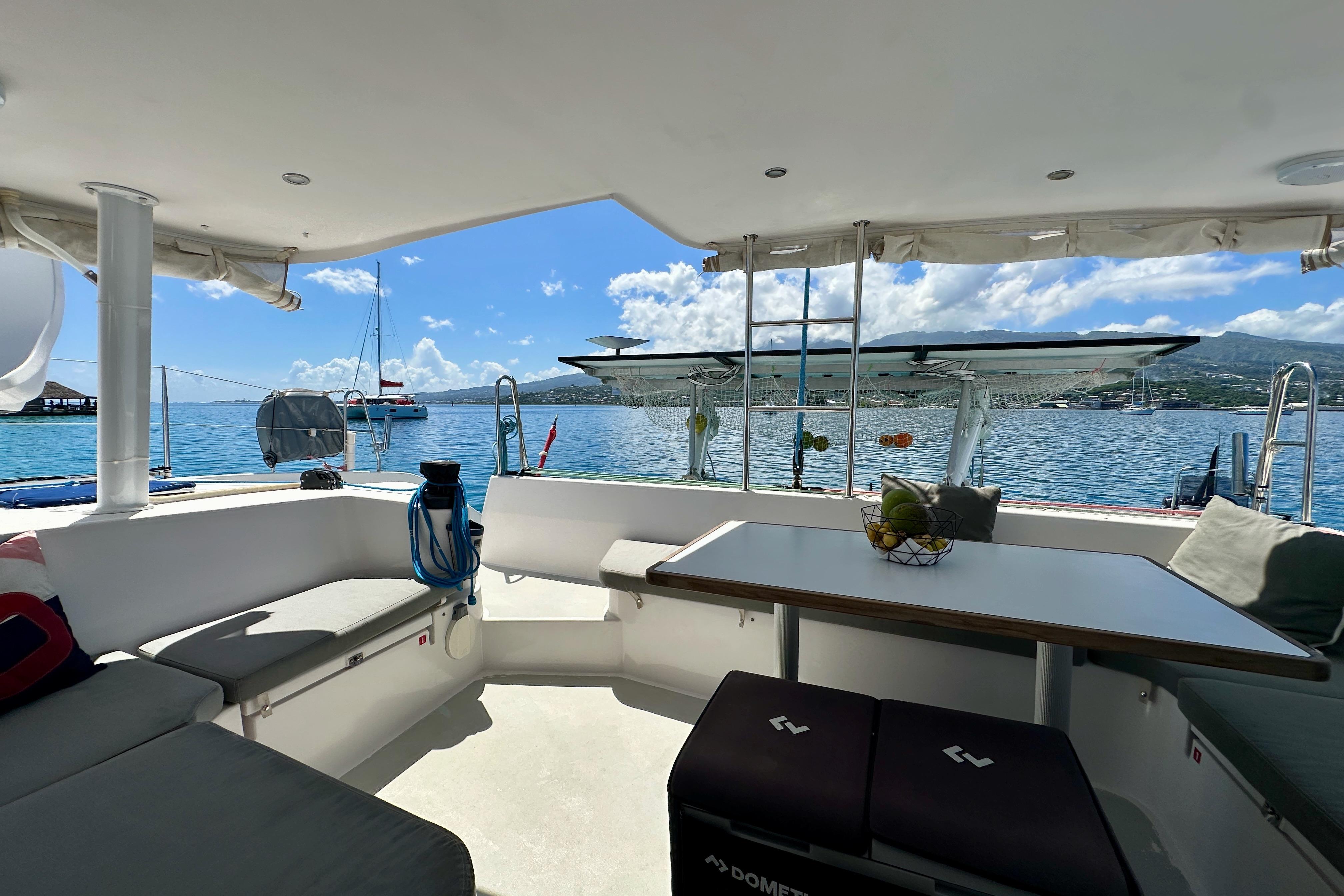 2019 Outremer 45 catamaran interior with ocean view, featuring seating and table.