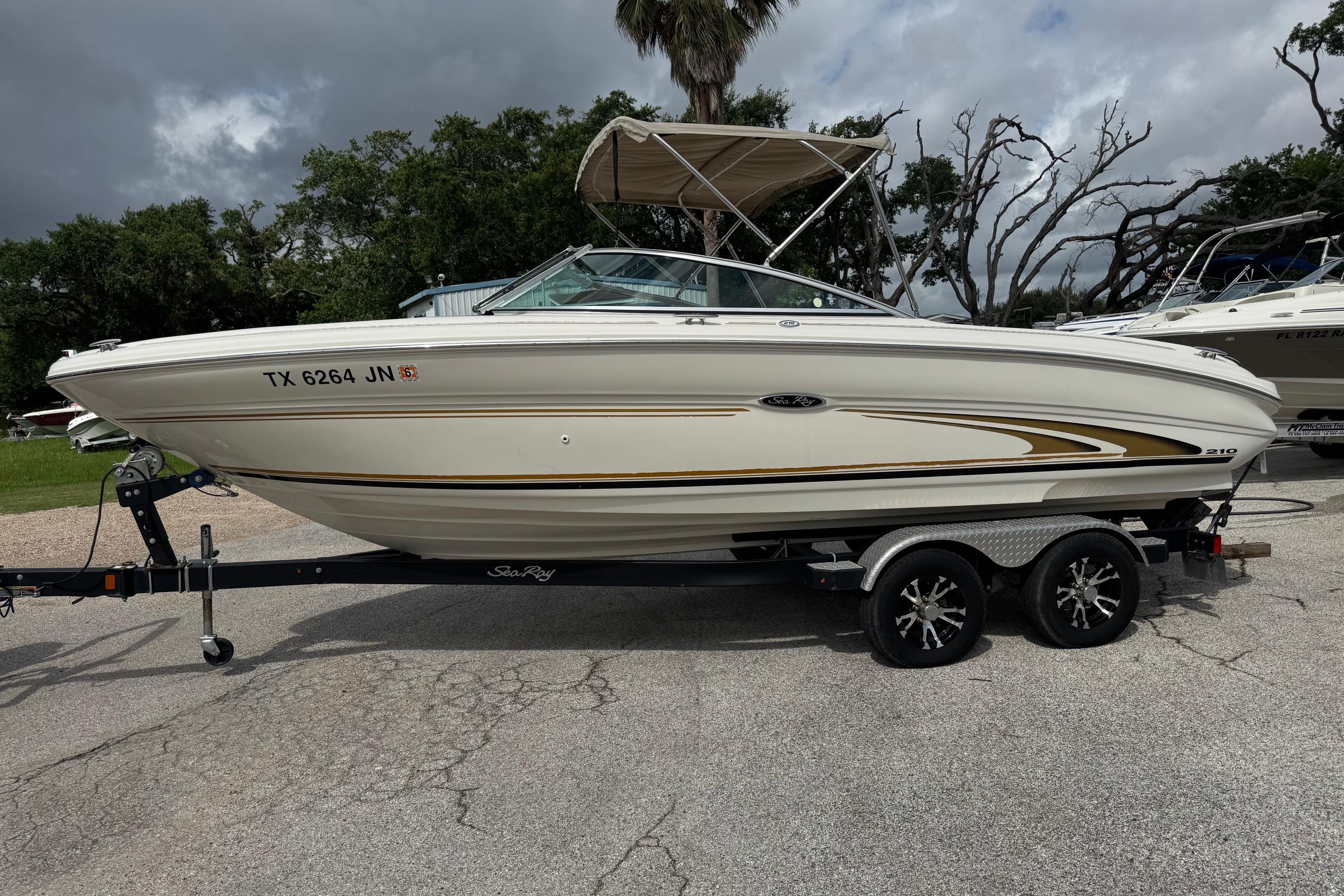 2001 Sea Ray 210 Bow Rider boat on trailer, parked outdoors under cloudy sky.
