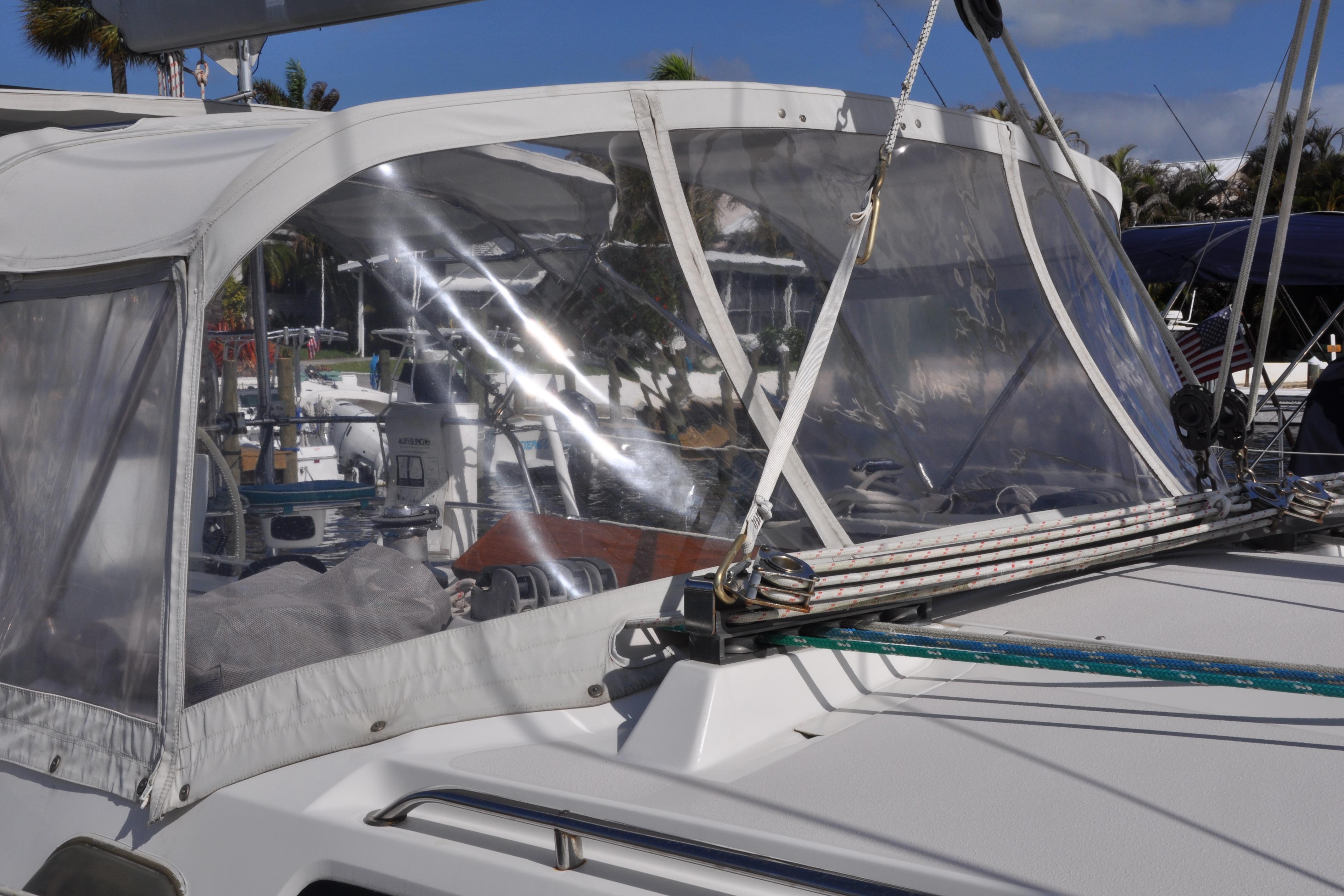 2003 Catalina 387 sailboat with clear cockpit enclosure and visible rigging.