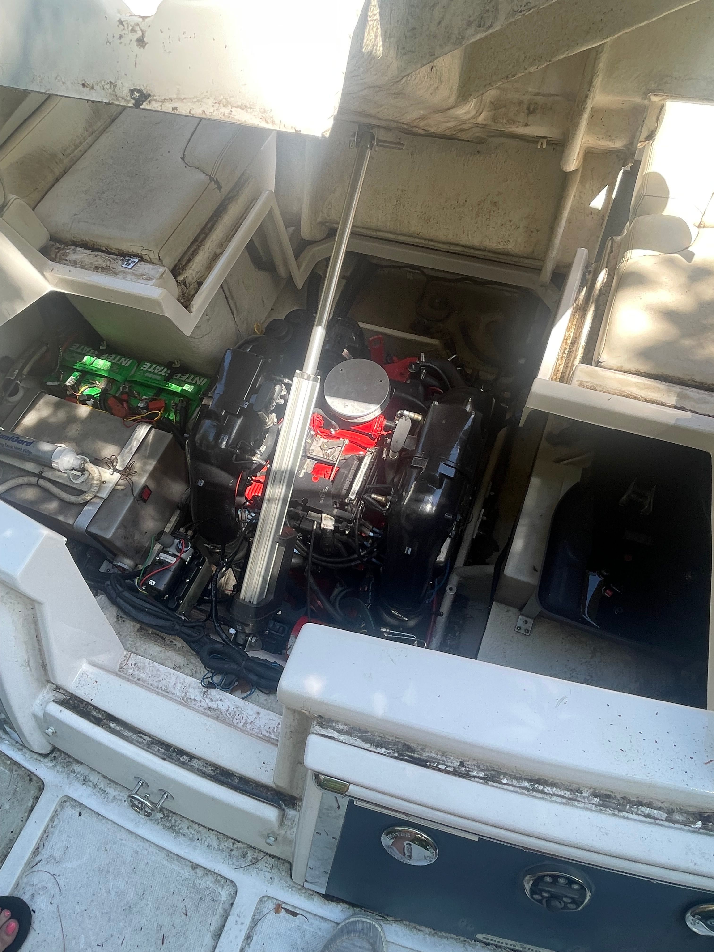 An open engine compartment of a 2011 Regal 2750 Cuddy showing the engine and batteries.